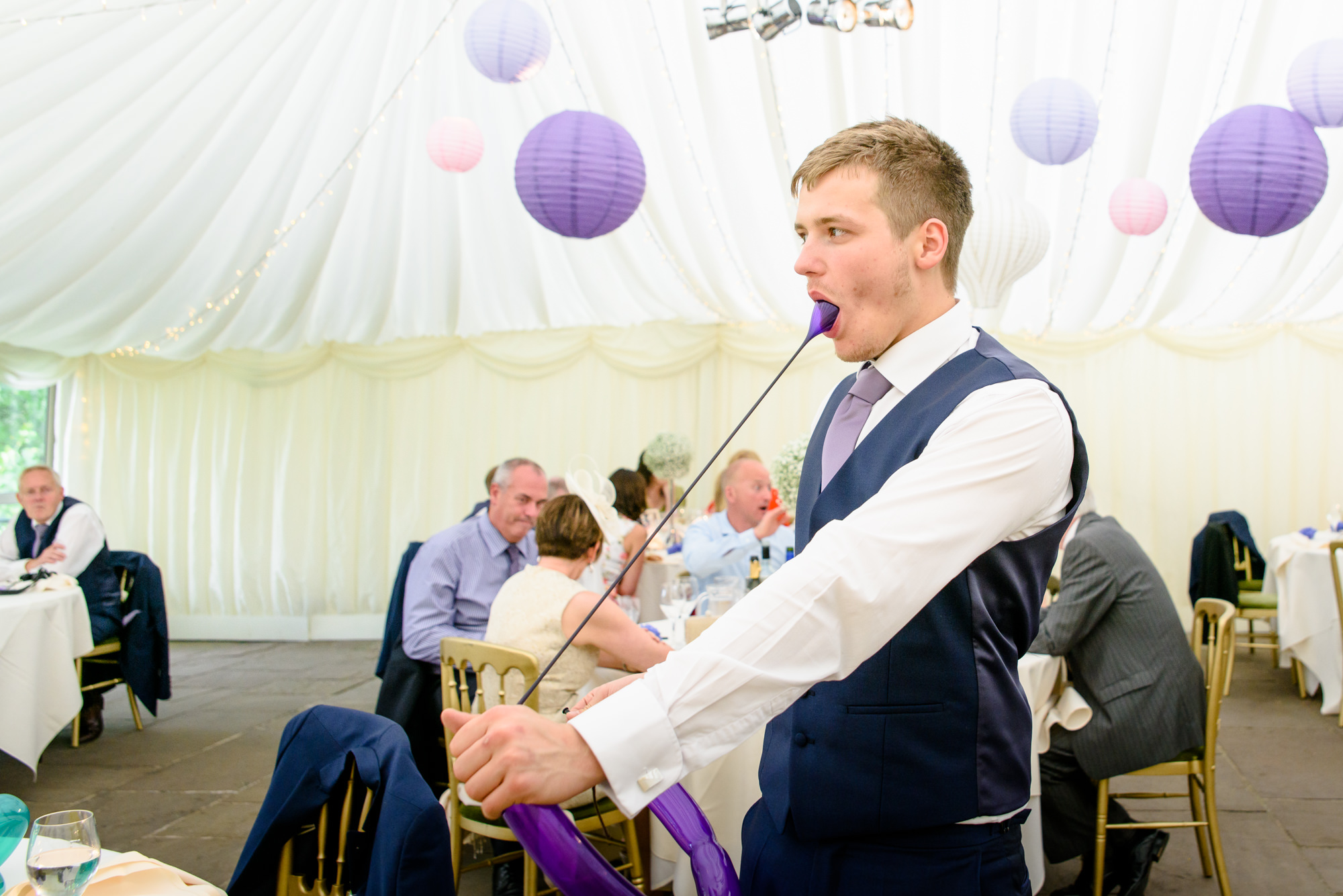 wedding guest trying to make a dog with a balloon