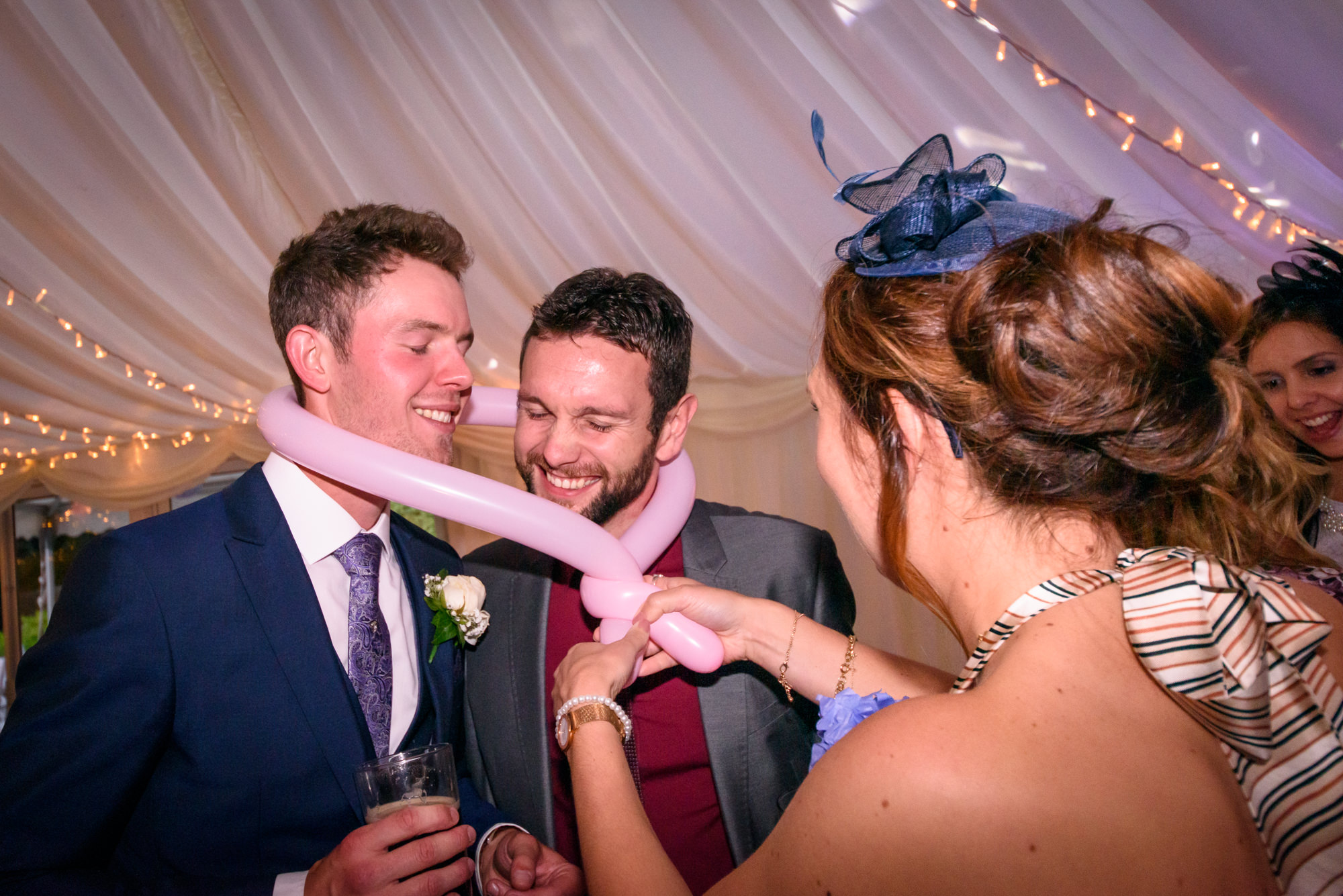 Groom and a guest being tied together with a balloon