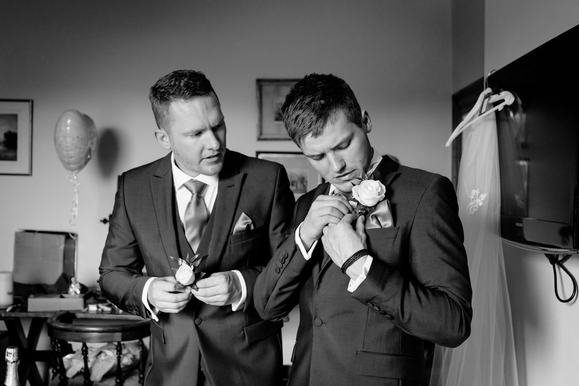 Groomsmen putting on the buttonhole flower