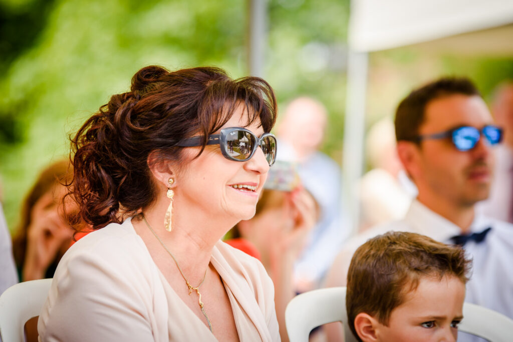 Mother of the bride with reflection of ceremony in her sunglasses