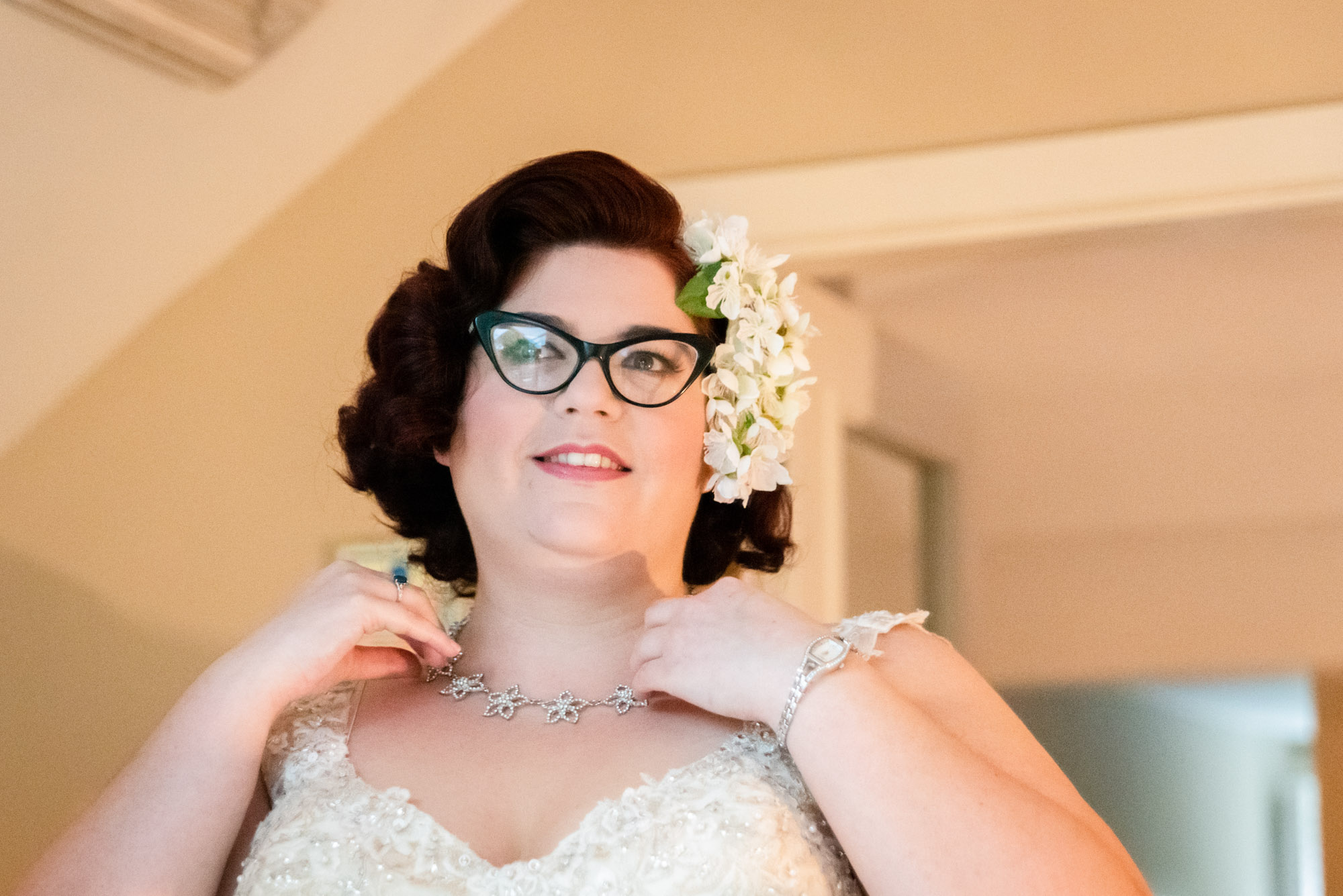 bride putting neckless on