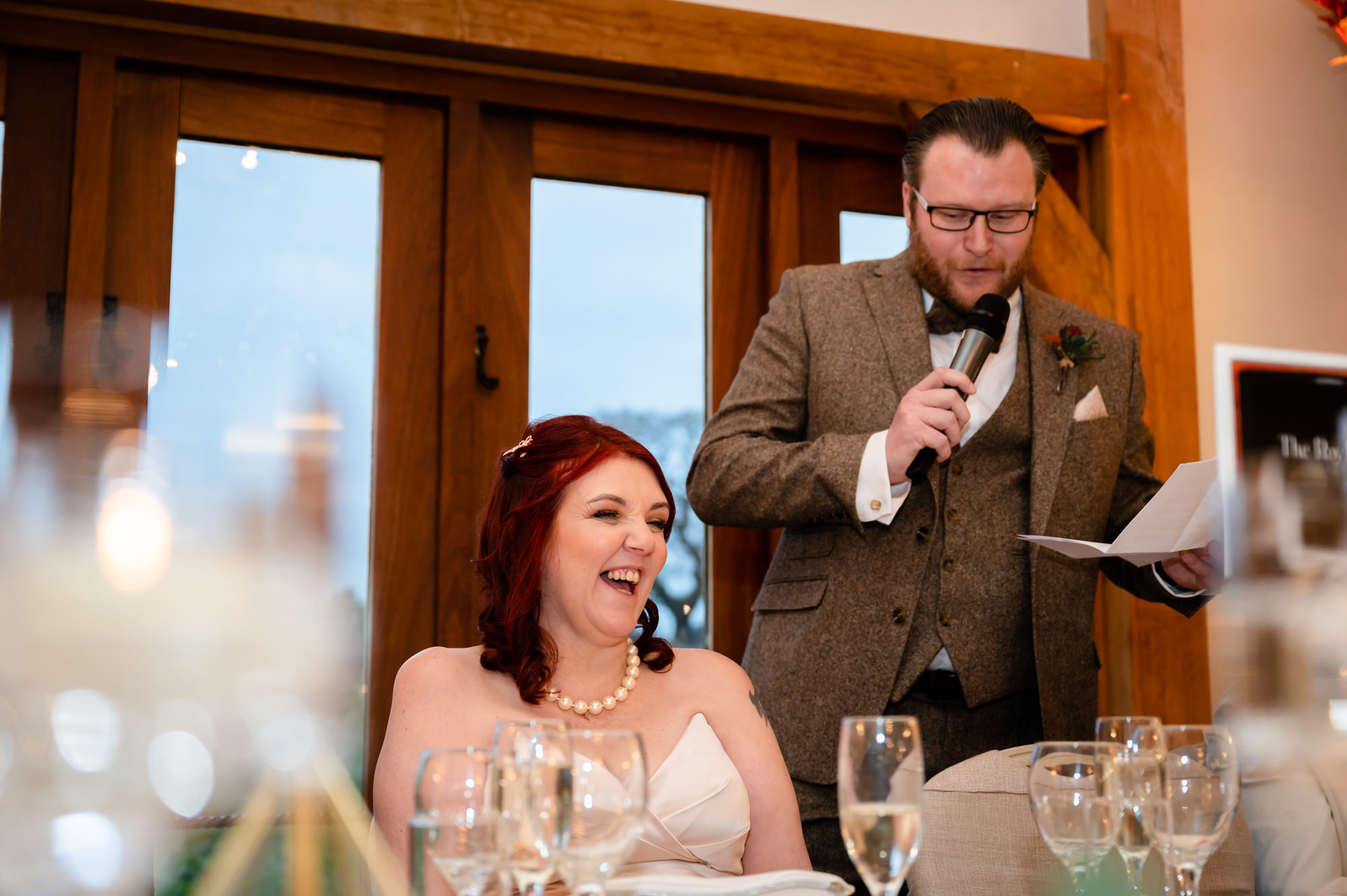 Bride laughing at the groom's speech Bride and groom exchanging vows at Sandhole Oak Barn