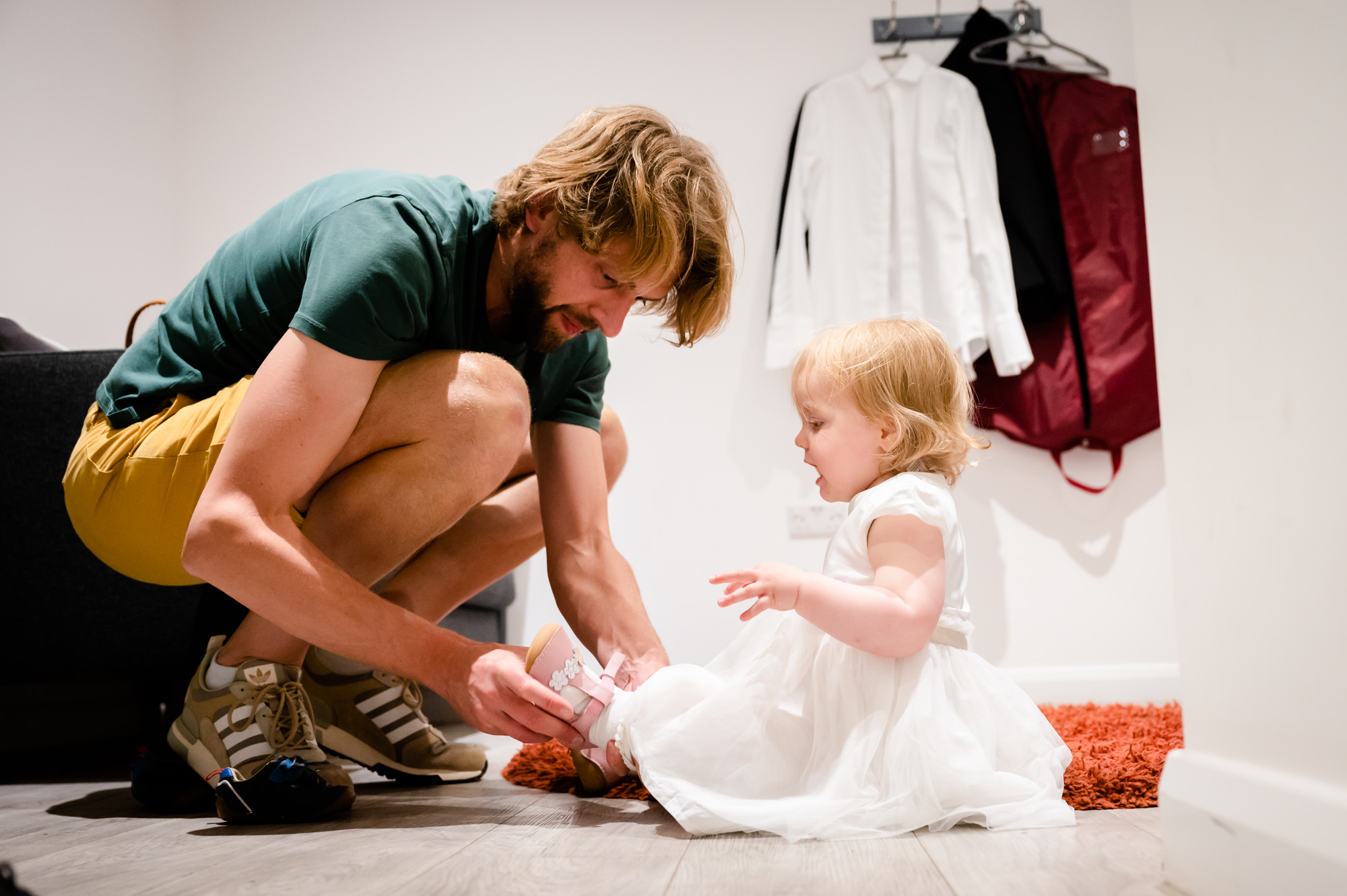 Groom dressing up the flower girl at Hanbury Wedding Barn