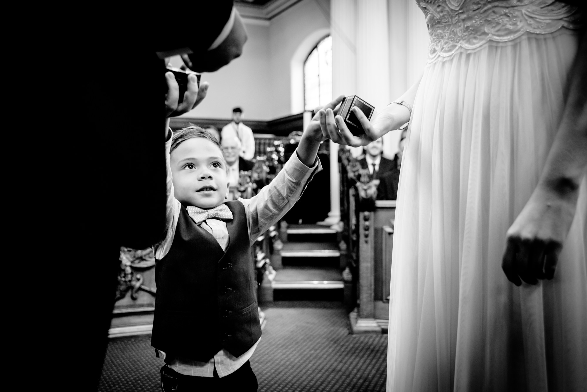 Little boy handing over the rings in the Council chamber at Stockport Town Hall