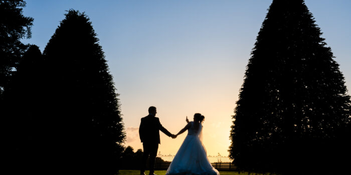 Bride and groom sunset photo with the bride giving the finger at Knowsley Hall