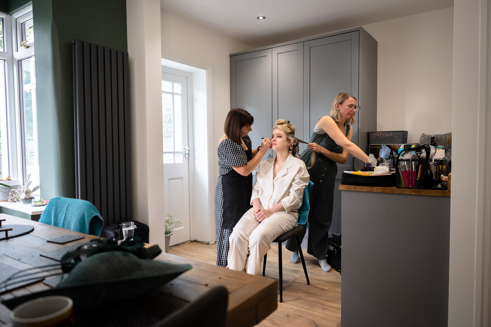 Bride having her make up and hair done in her house 