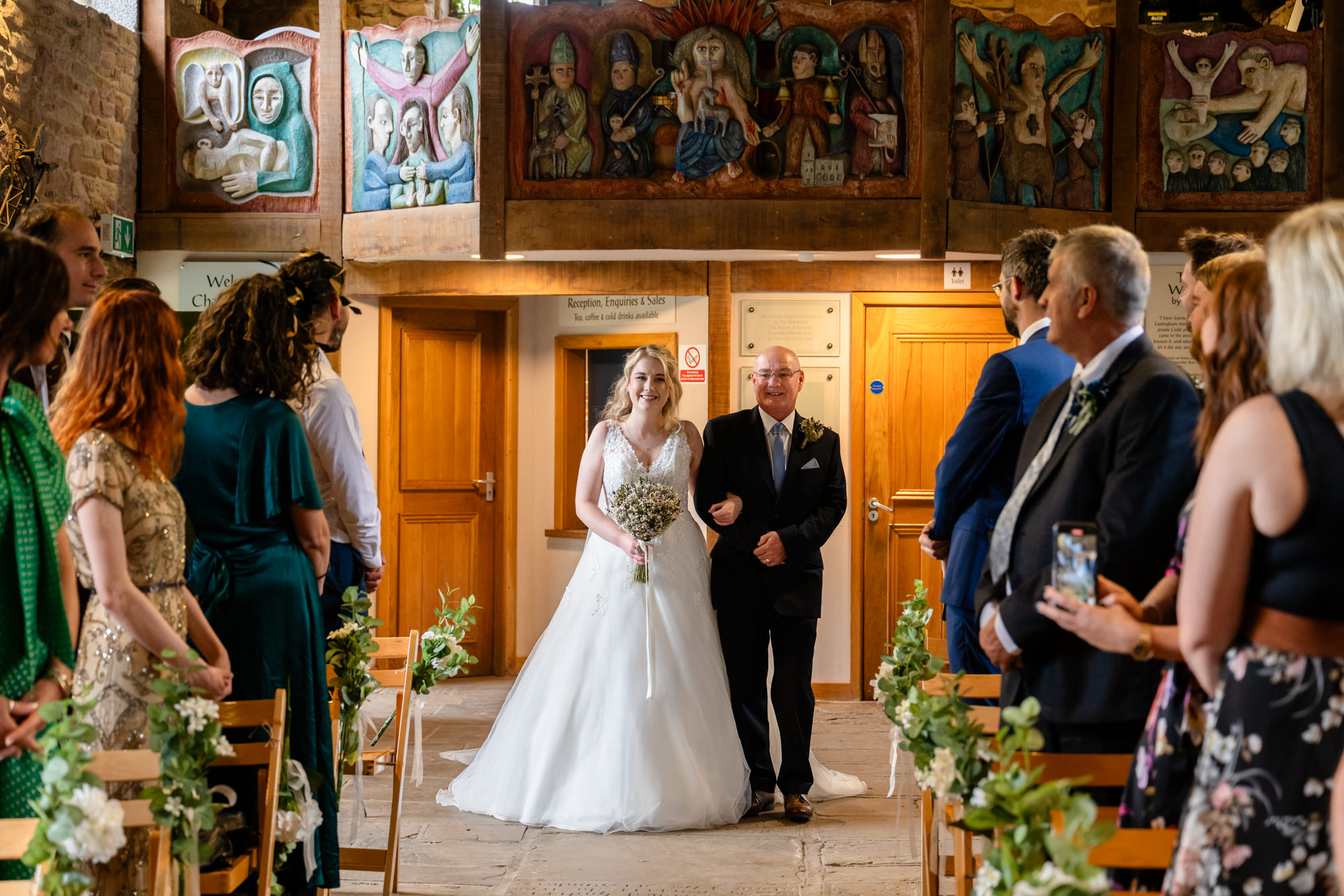 Bride walking down the ailse with her dad at Chadkirk Chapel