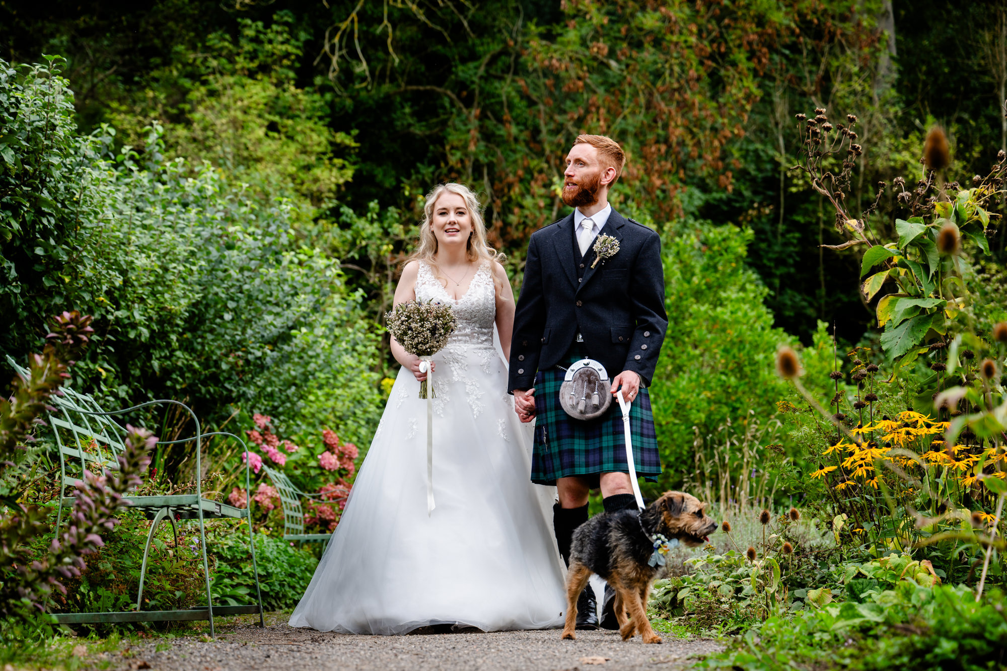 bride and groom walking their dog at Chadkirk Chapel