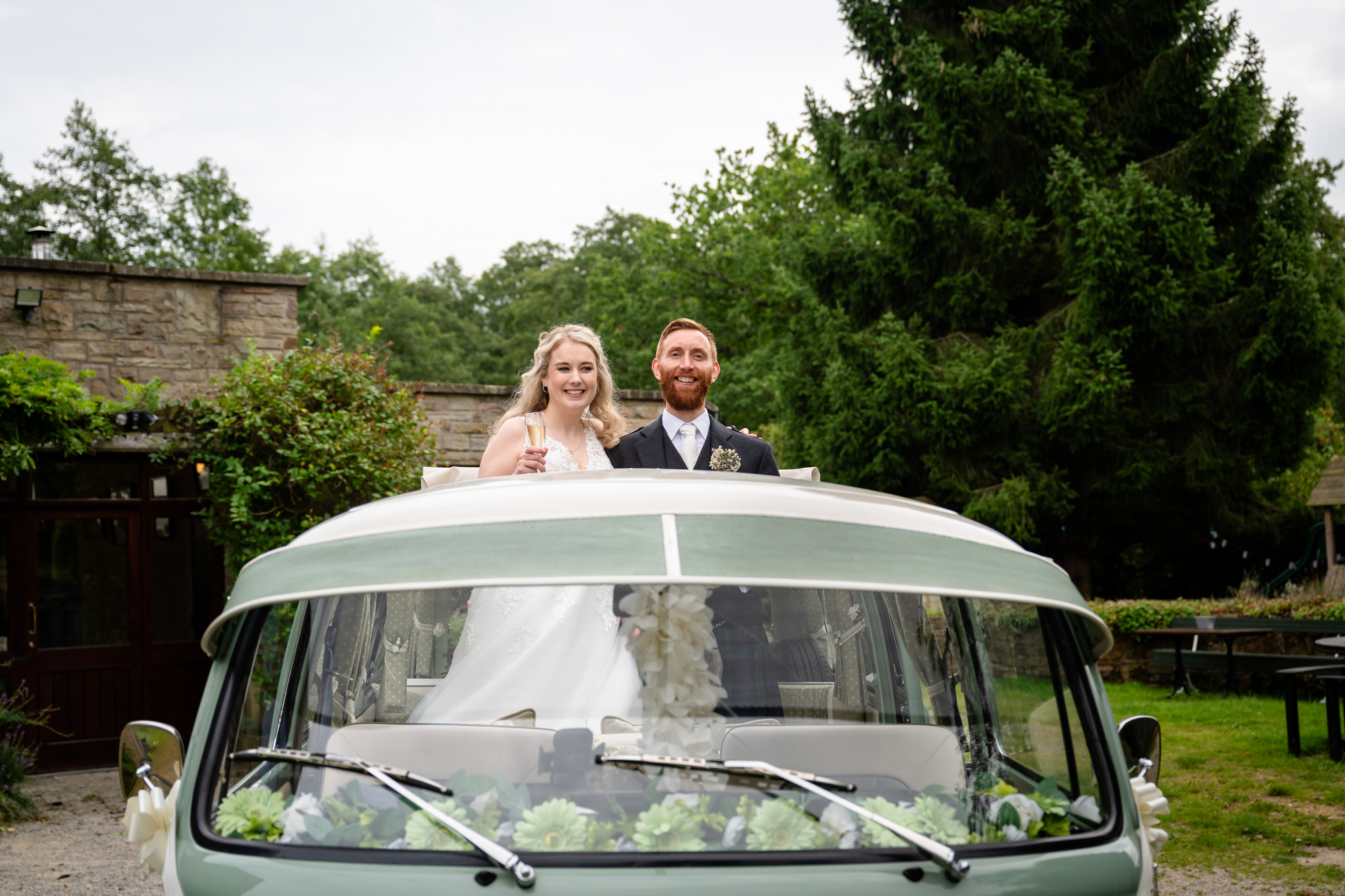 Bride and groom sticking their heads out the camper van at The Roman Lakes