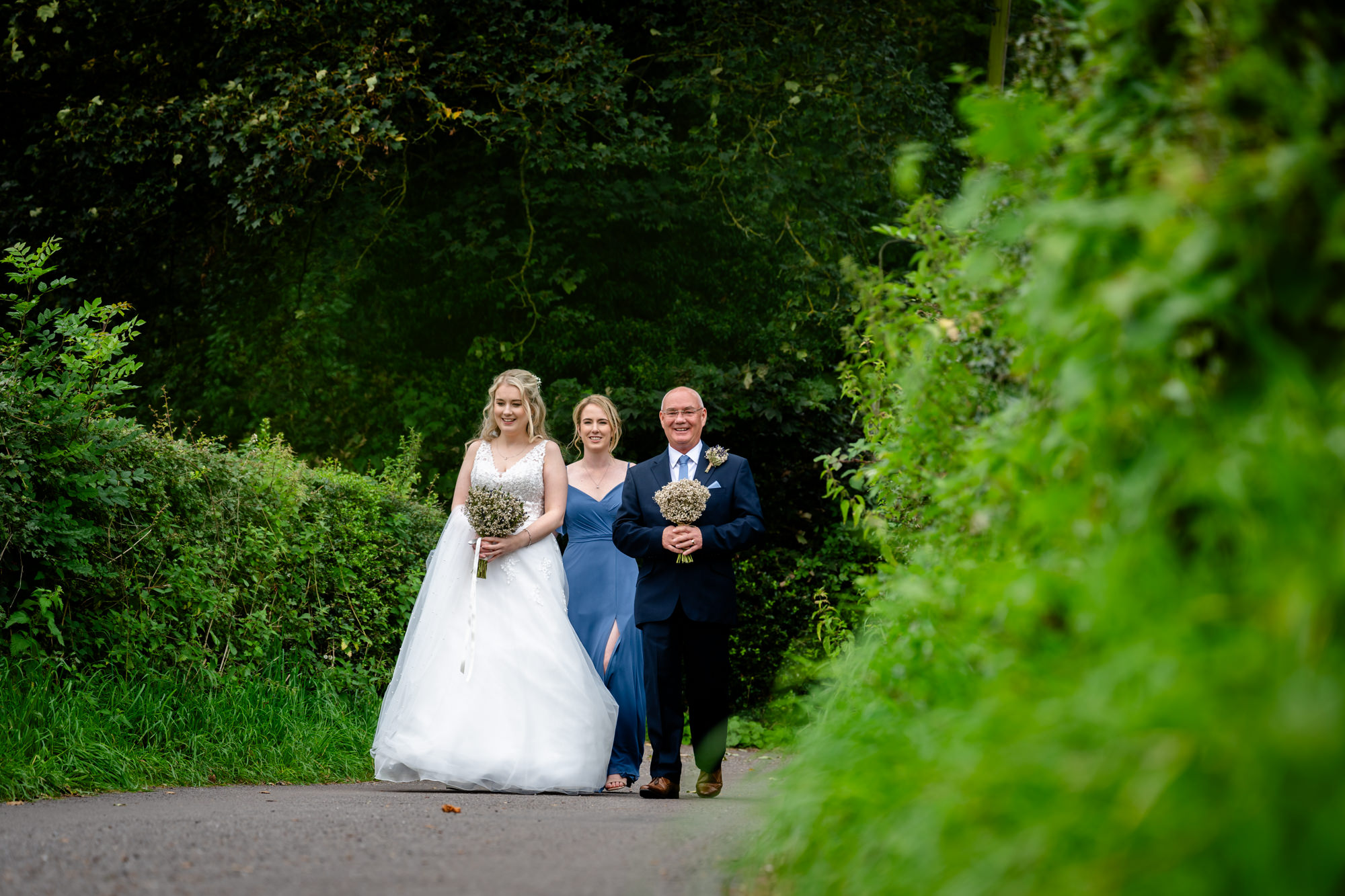 Bride with her dad and sister walking to Chadkirk Chapel