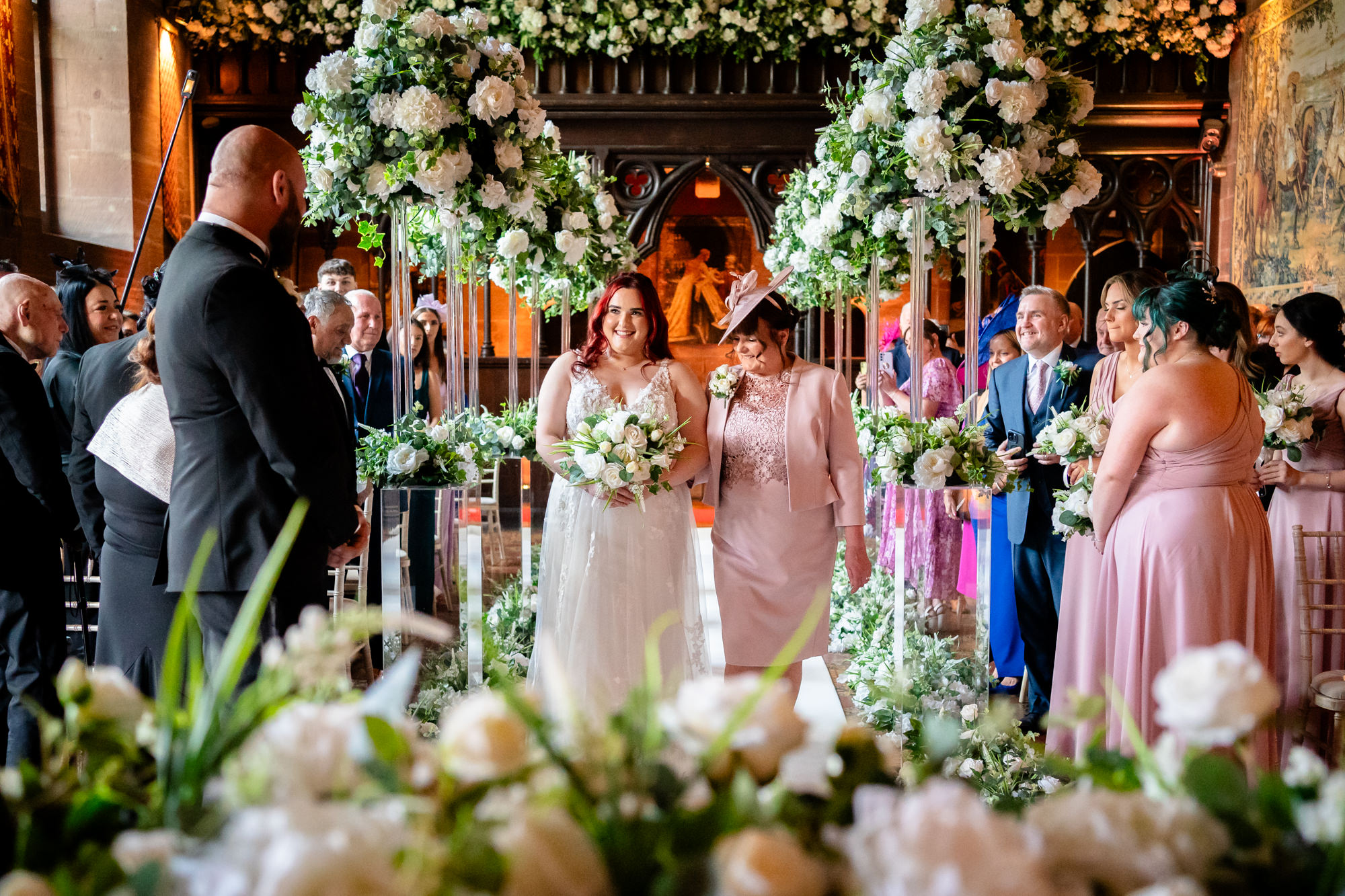 Bride walking down the aisle with her mother at Peckforton Castle