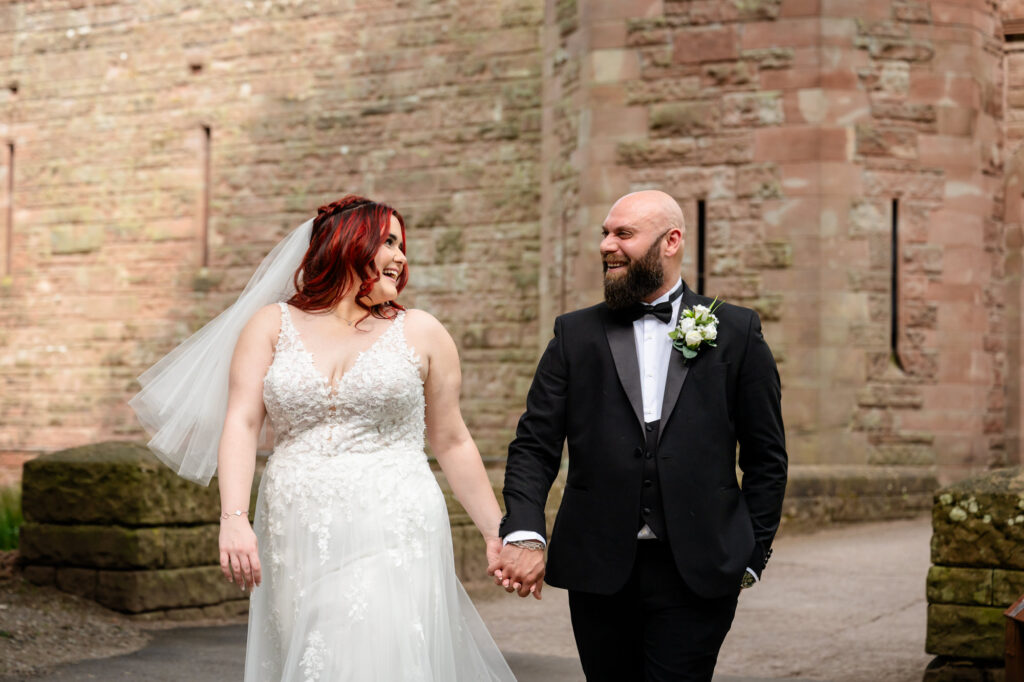 Bride and groom walking around Peckforton Castle