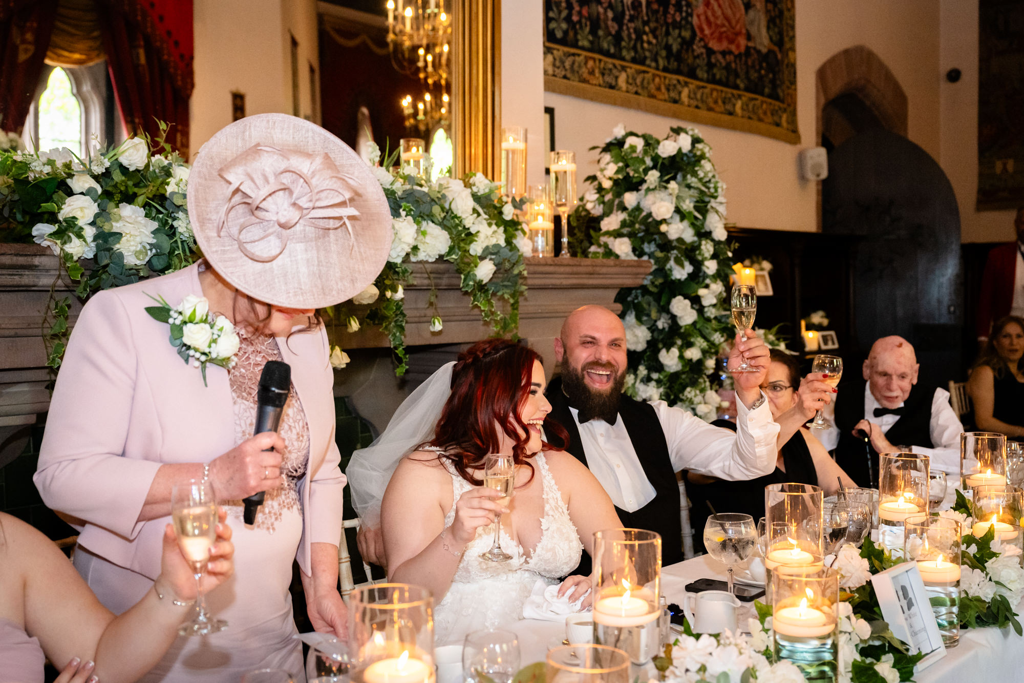 Bride and groom laughing during the mother's speech at Peckforton Castle