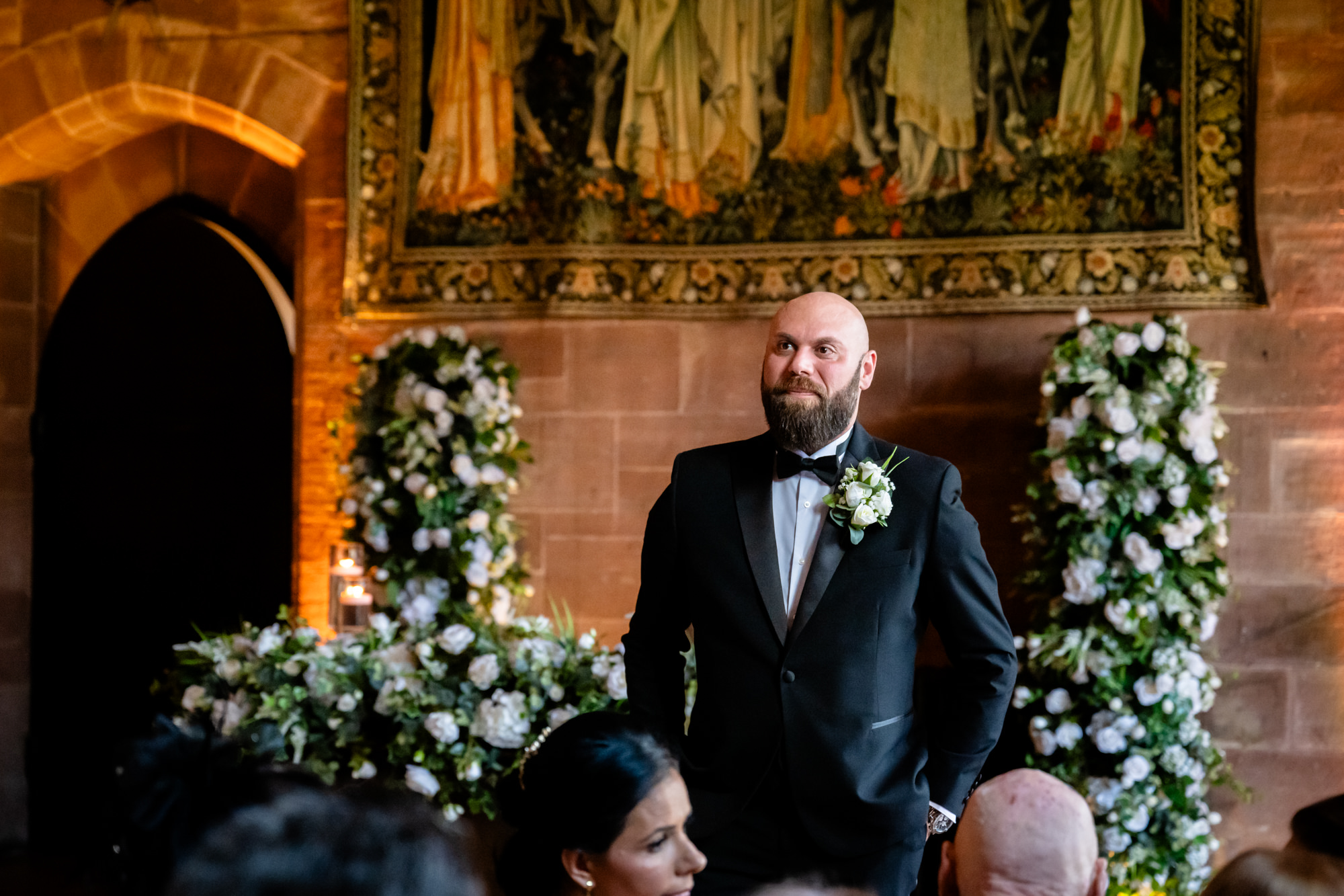 Groom waiting down the aisle at Peckforton Castle