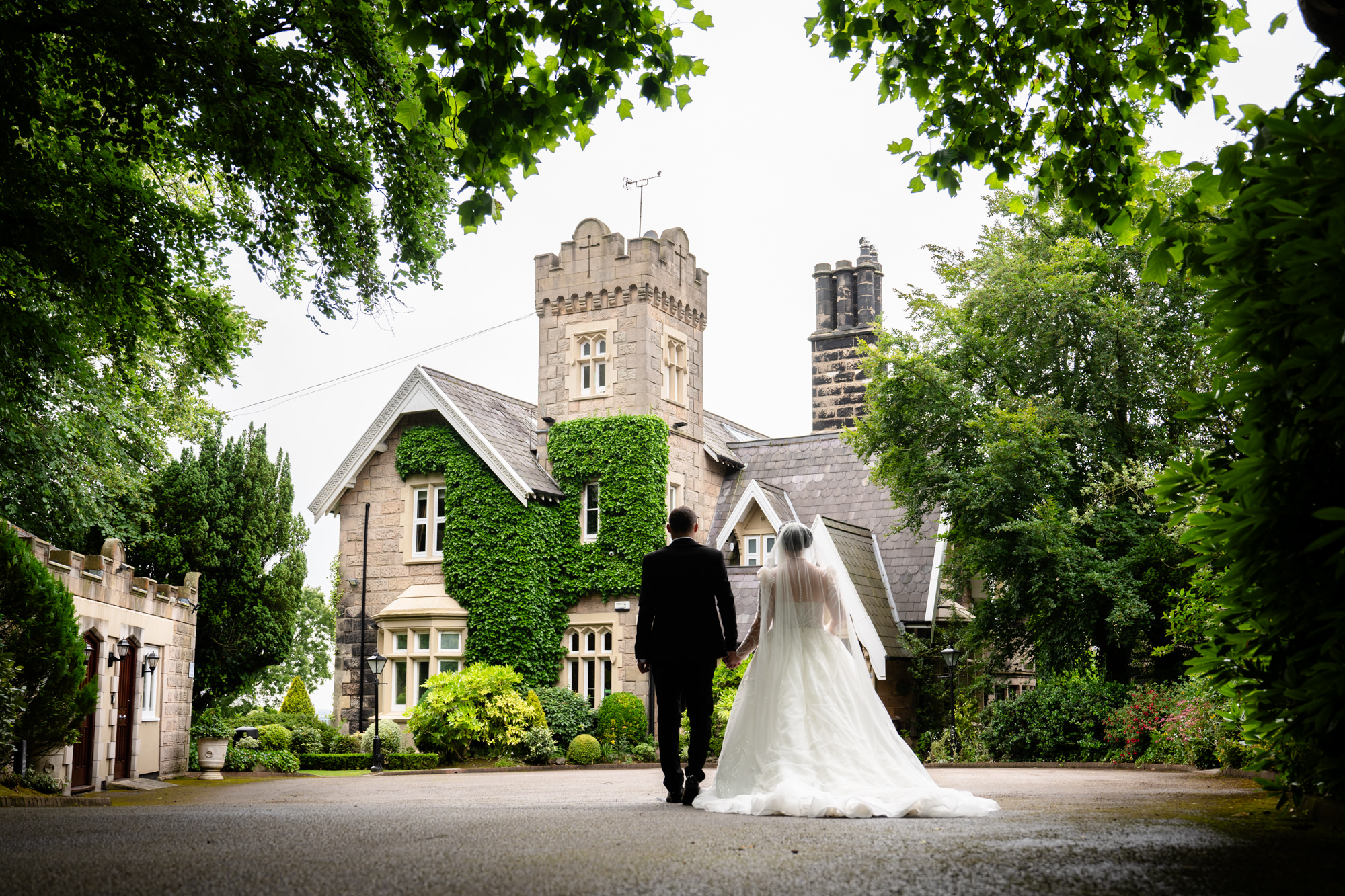 Bride and groom walking towards West Tower entrance