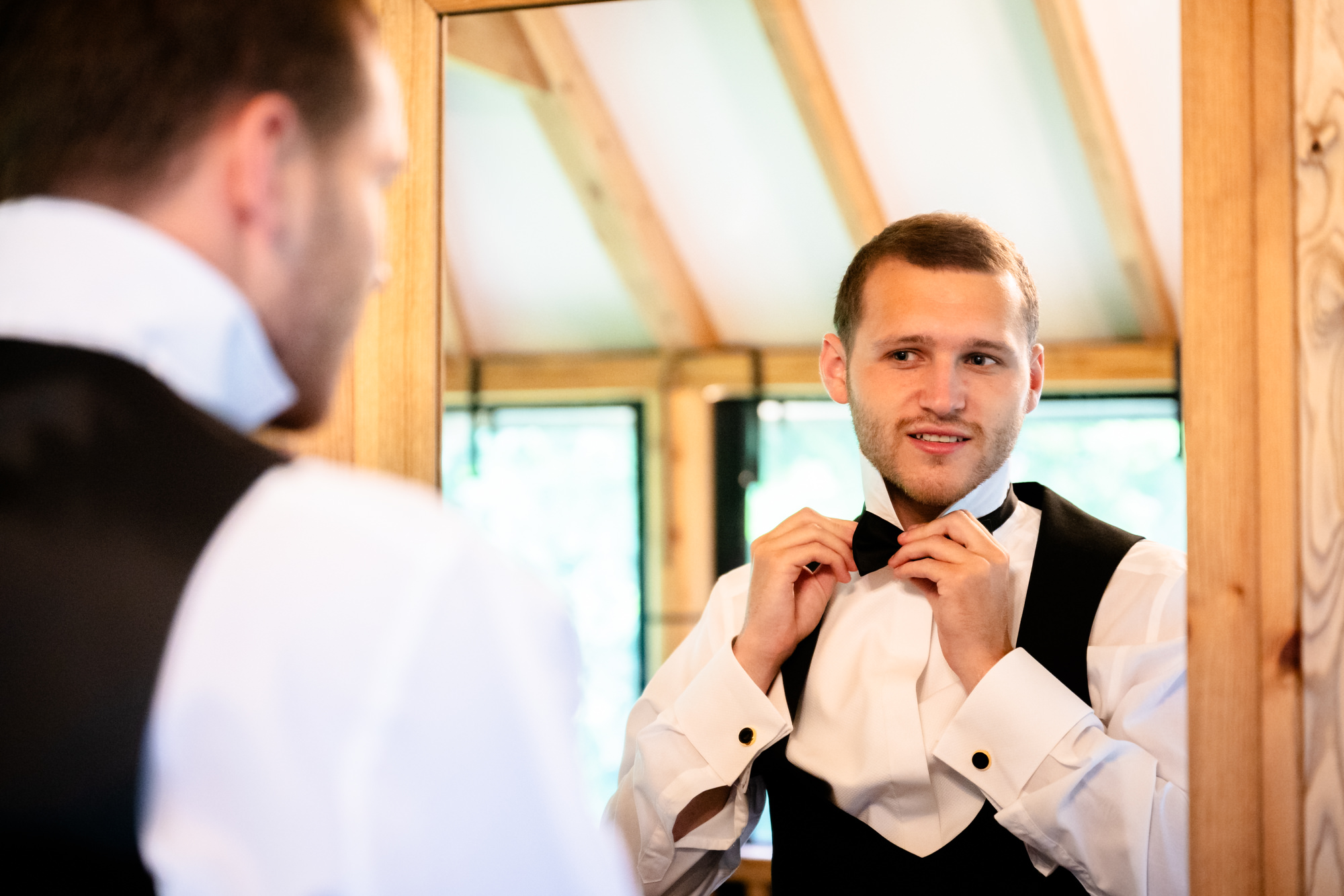 Groom putting his bow tie on