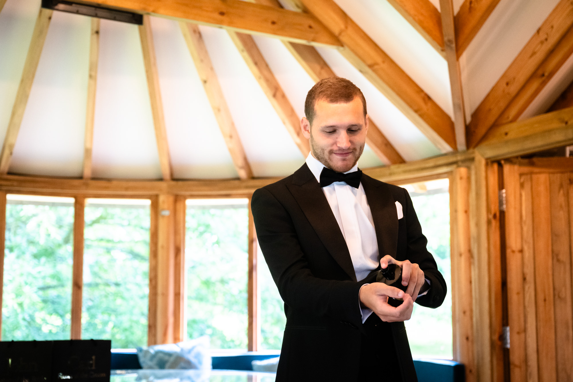 Groom spraying aftershave on his wrist at West Tower 