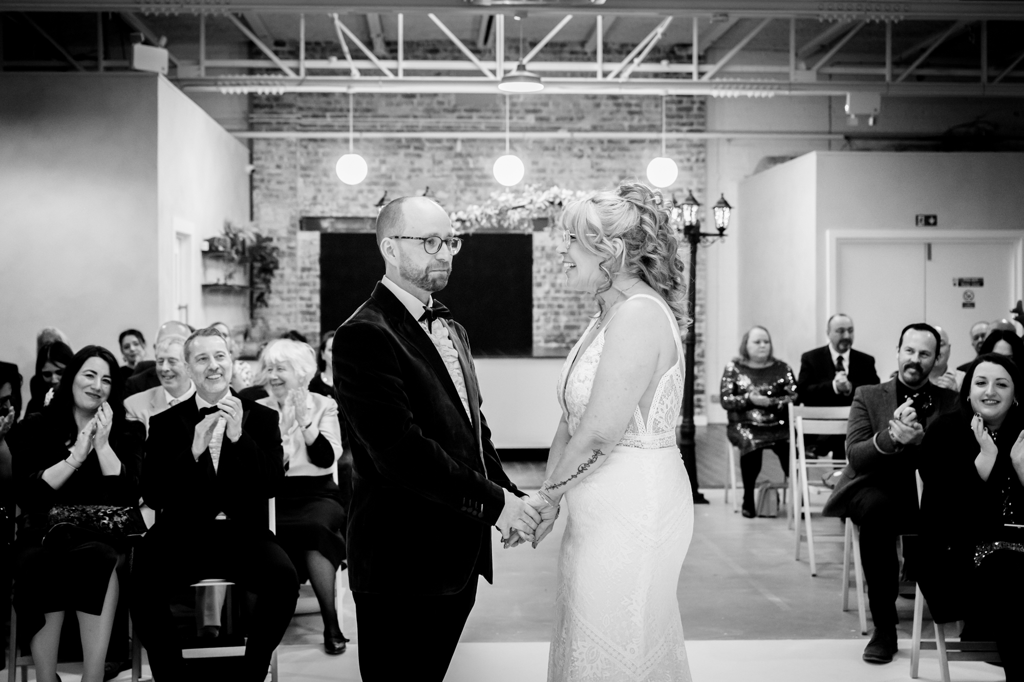 Groom looking emotional while the bride is laughing at hime at Fabric