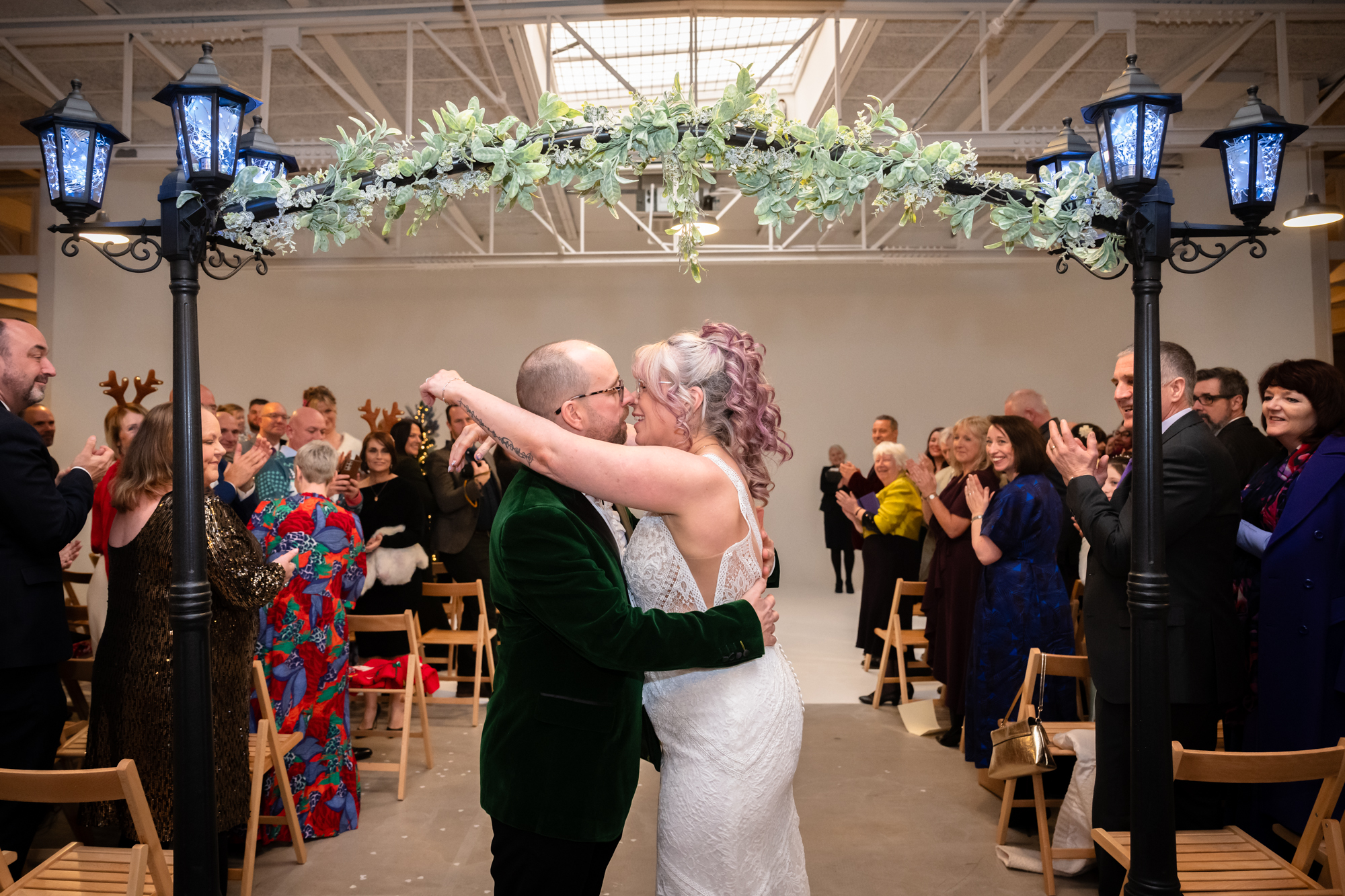 Bride and groom kissing down the aisle