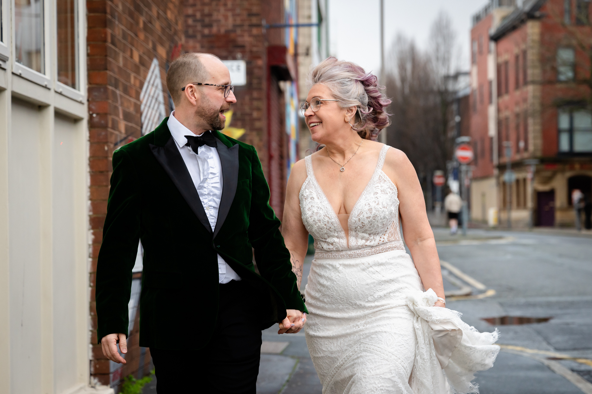 Bride and groom walking outside Scale. The wind is blowing