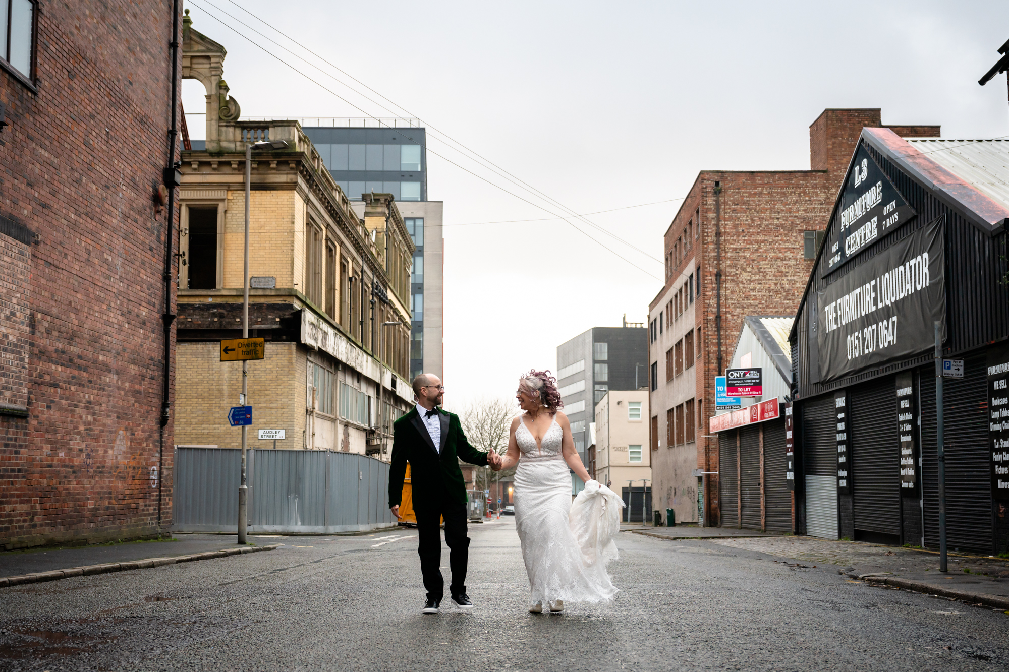 Bride and groom walking on the road outside Scale