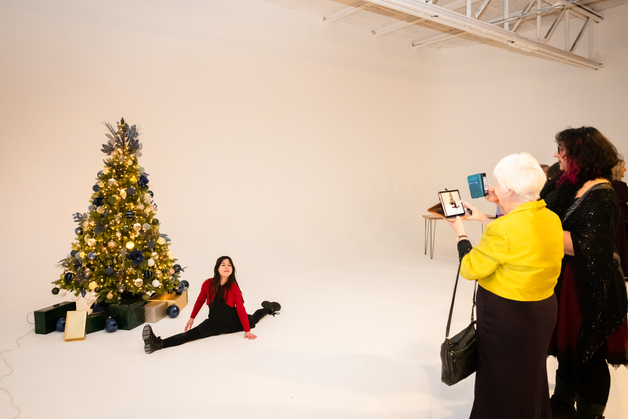 Young girl doing the split in front of a Christmas tree at Fabric Studio