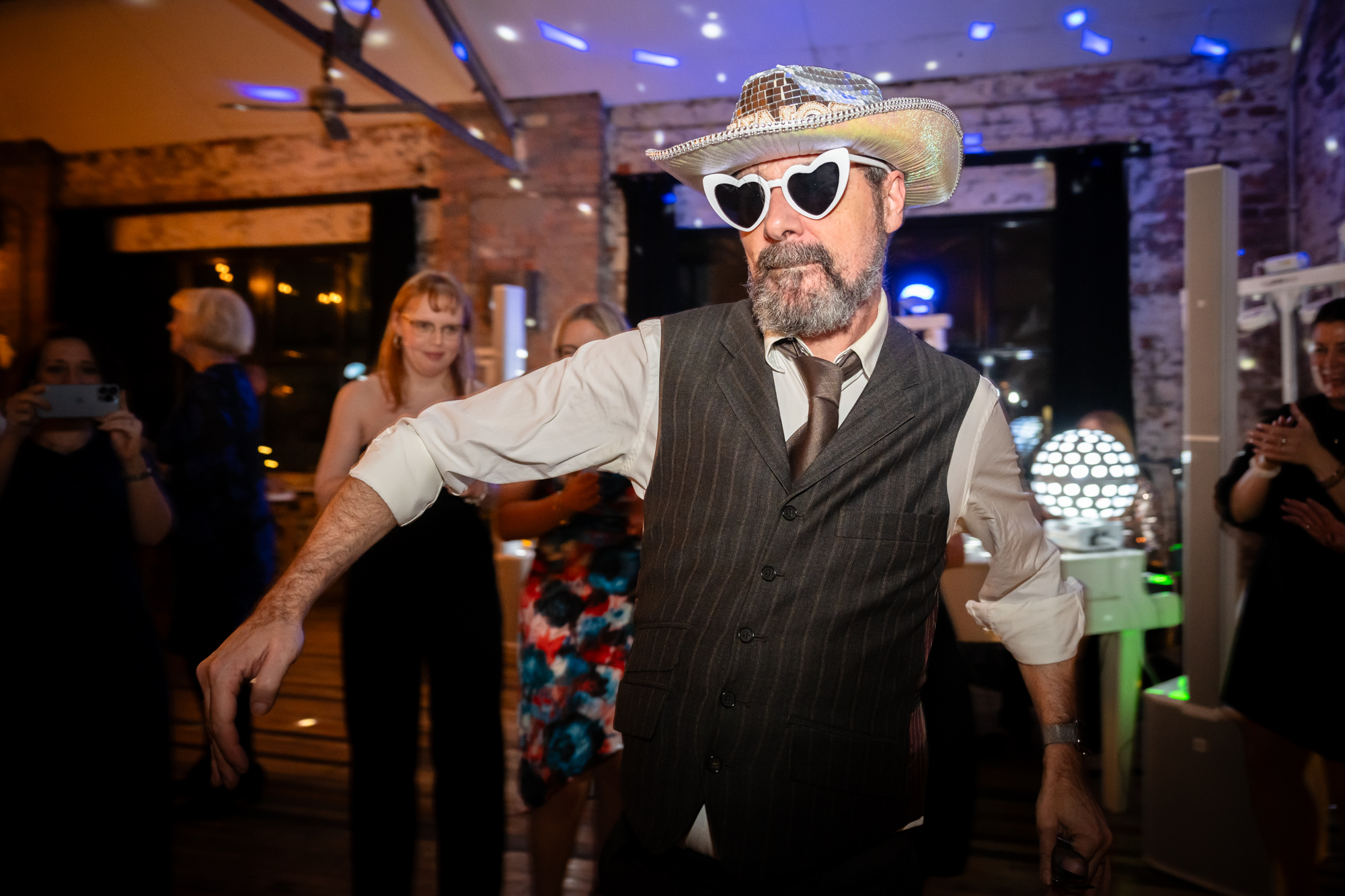 Guest dancing with a cowboy hat and sunglasses