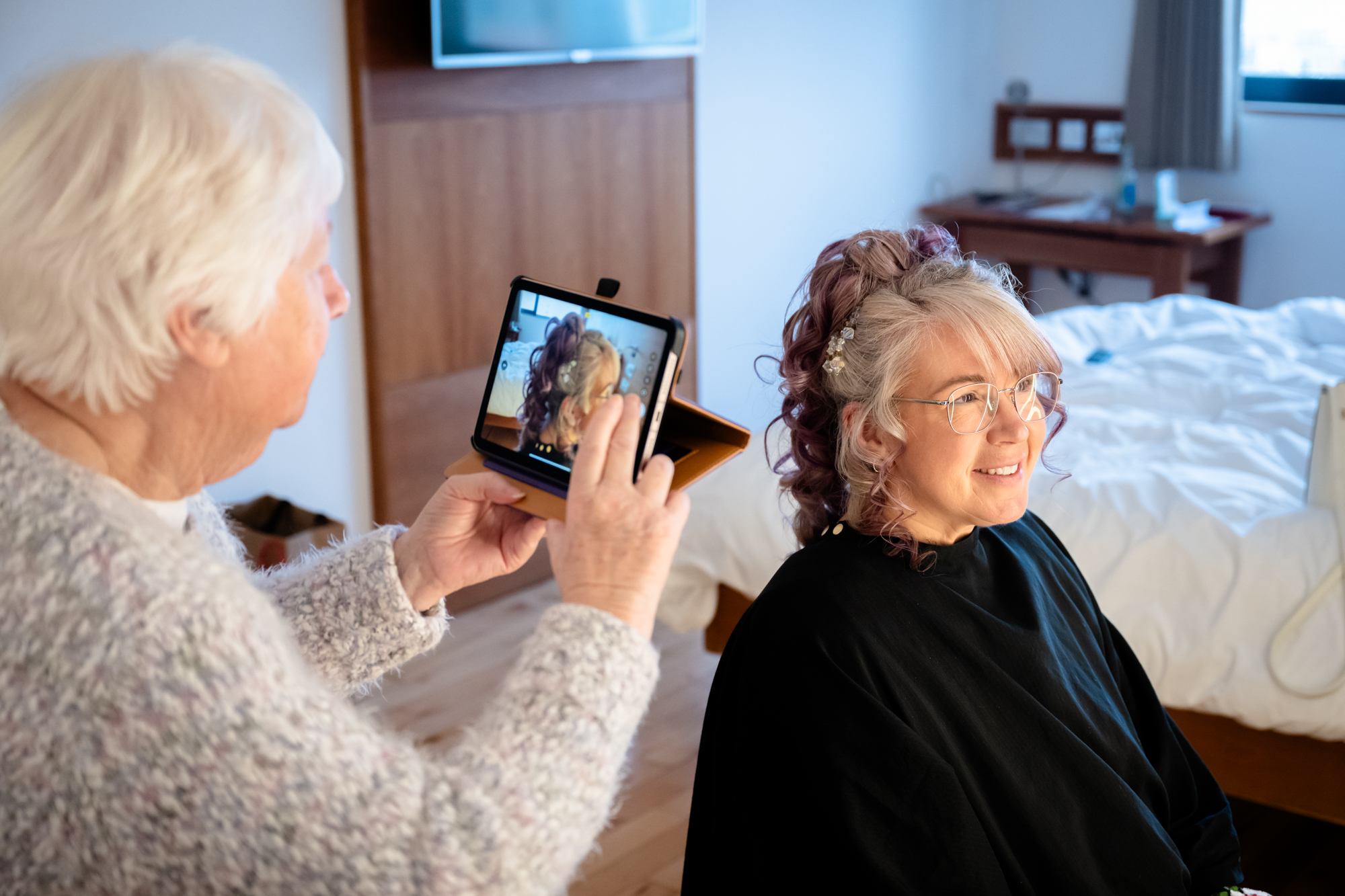 Mother of the Bride taking a photo of the bride's hair