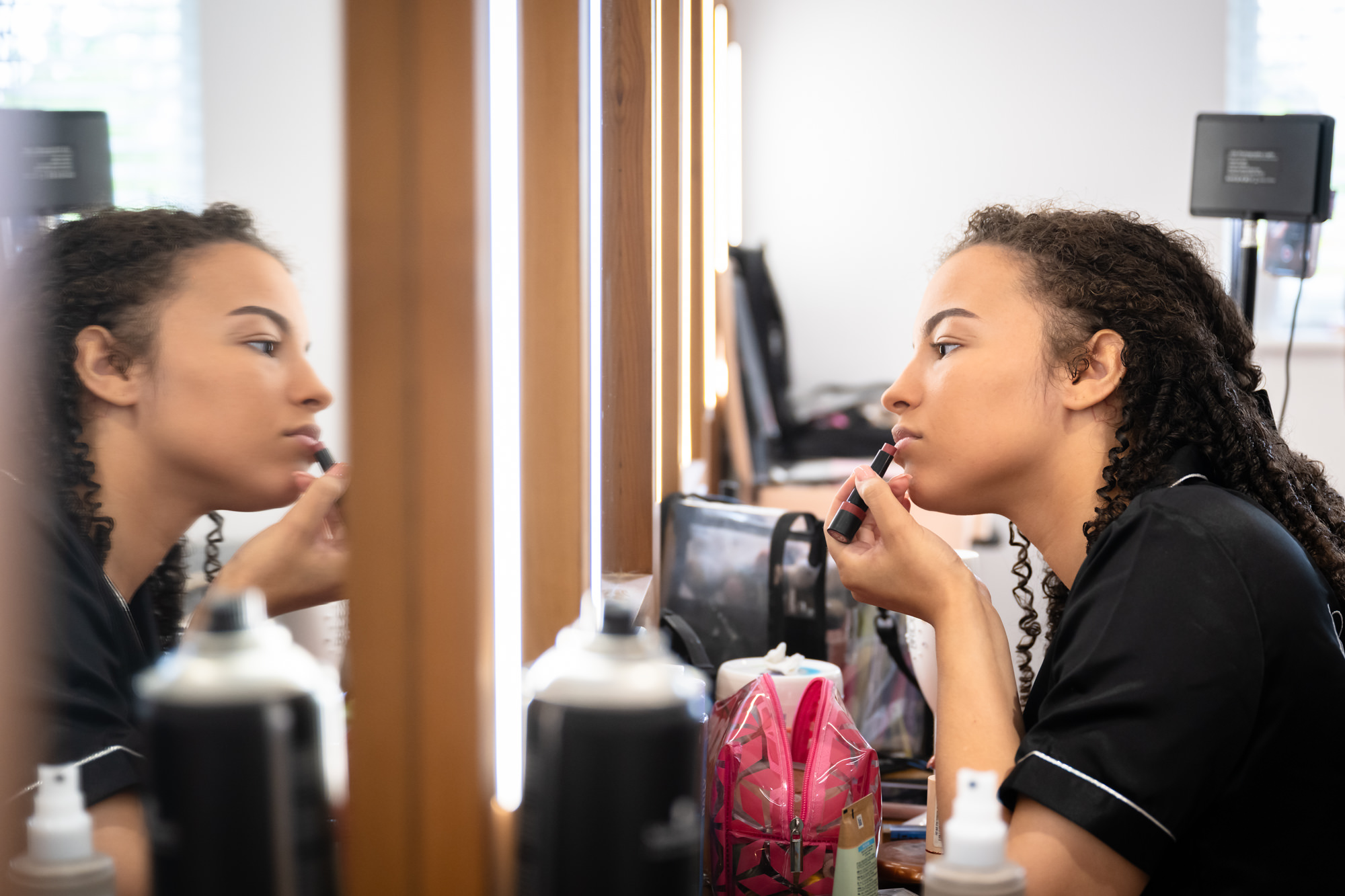 Bridesmaid doing her own makeup in the dressing room at Hanbury Barns