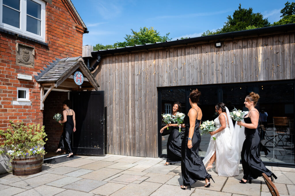 Bride and her bridesmaids entering the main barn at Hanbury Barns