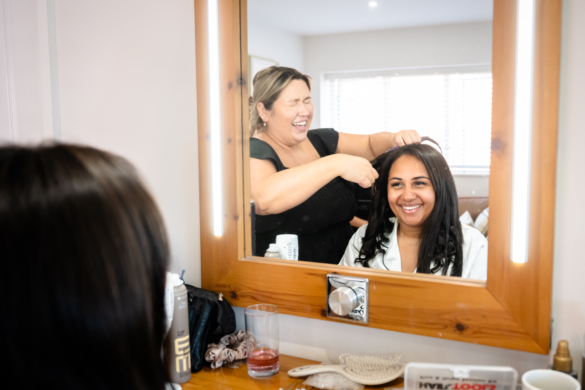 Bride having her hair done in the dressing room at Hanbury Barns