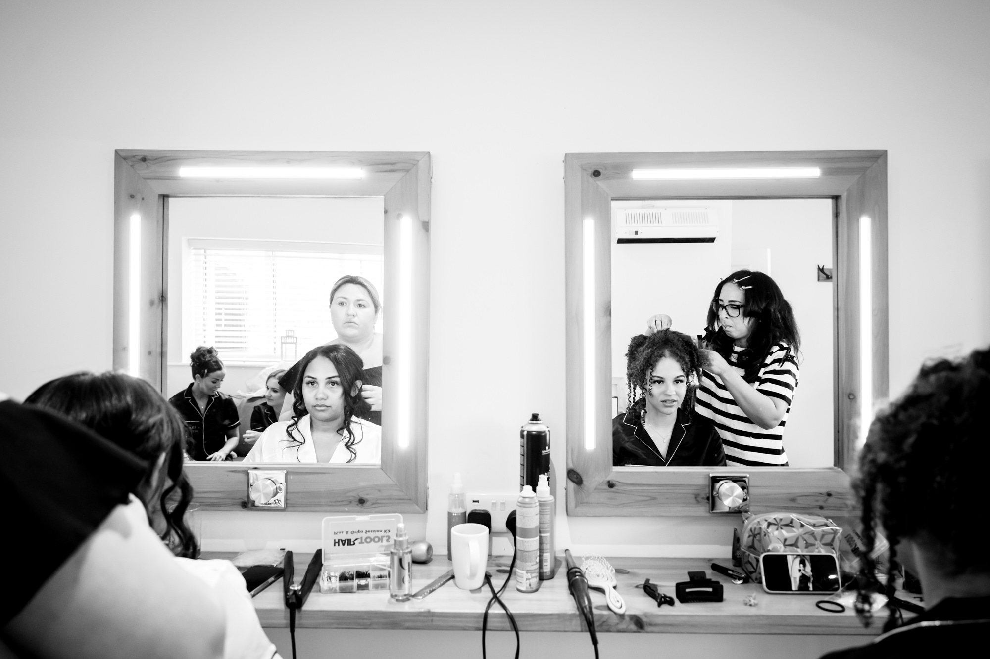 Reflection of the bride and her bridesmaid in the mirror in the dressing room at Hanbury Barns