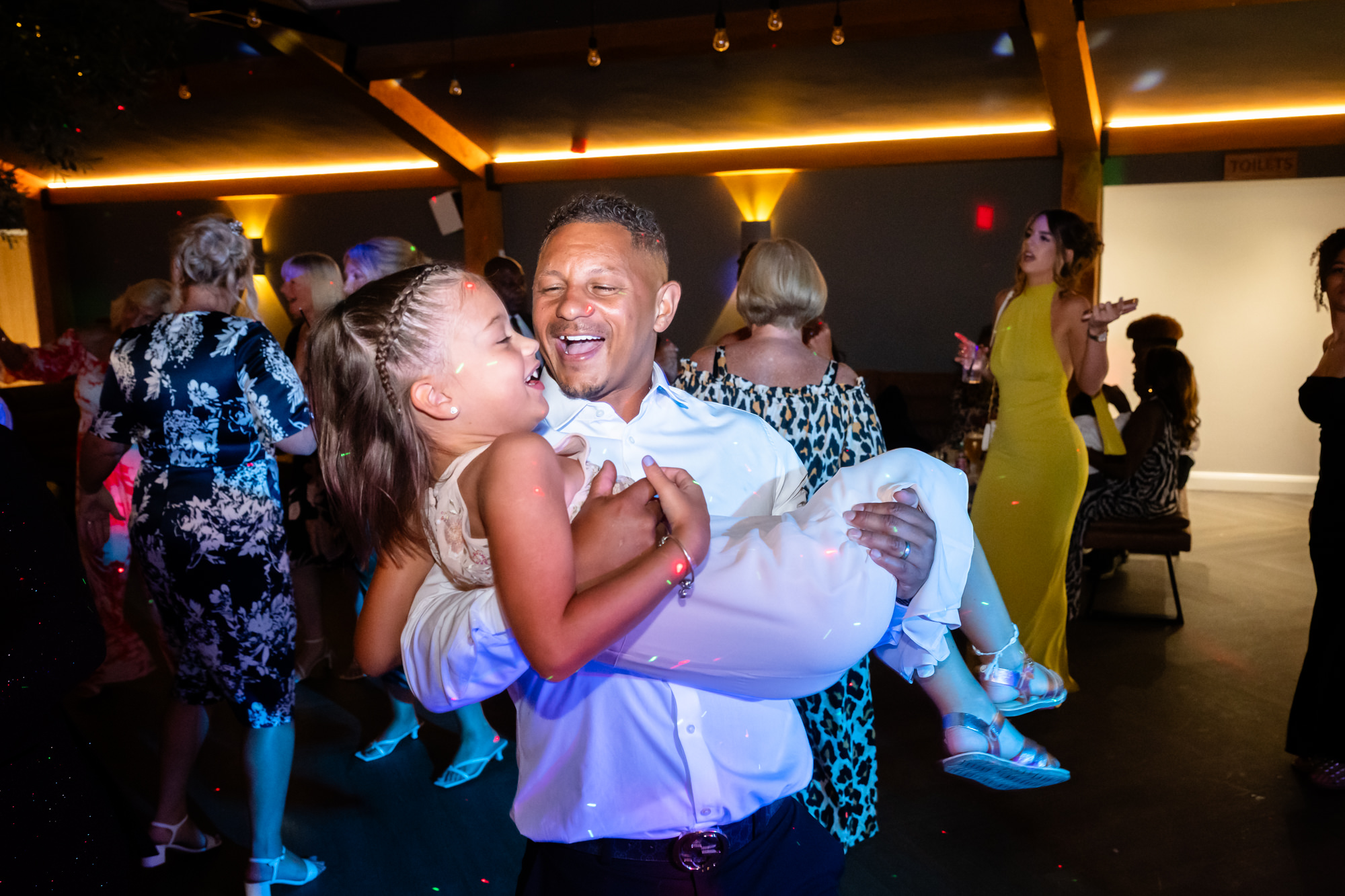 Guest dancing while holding a little girl