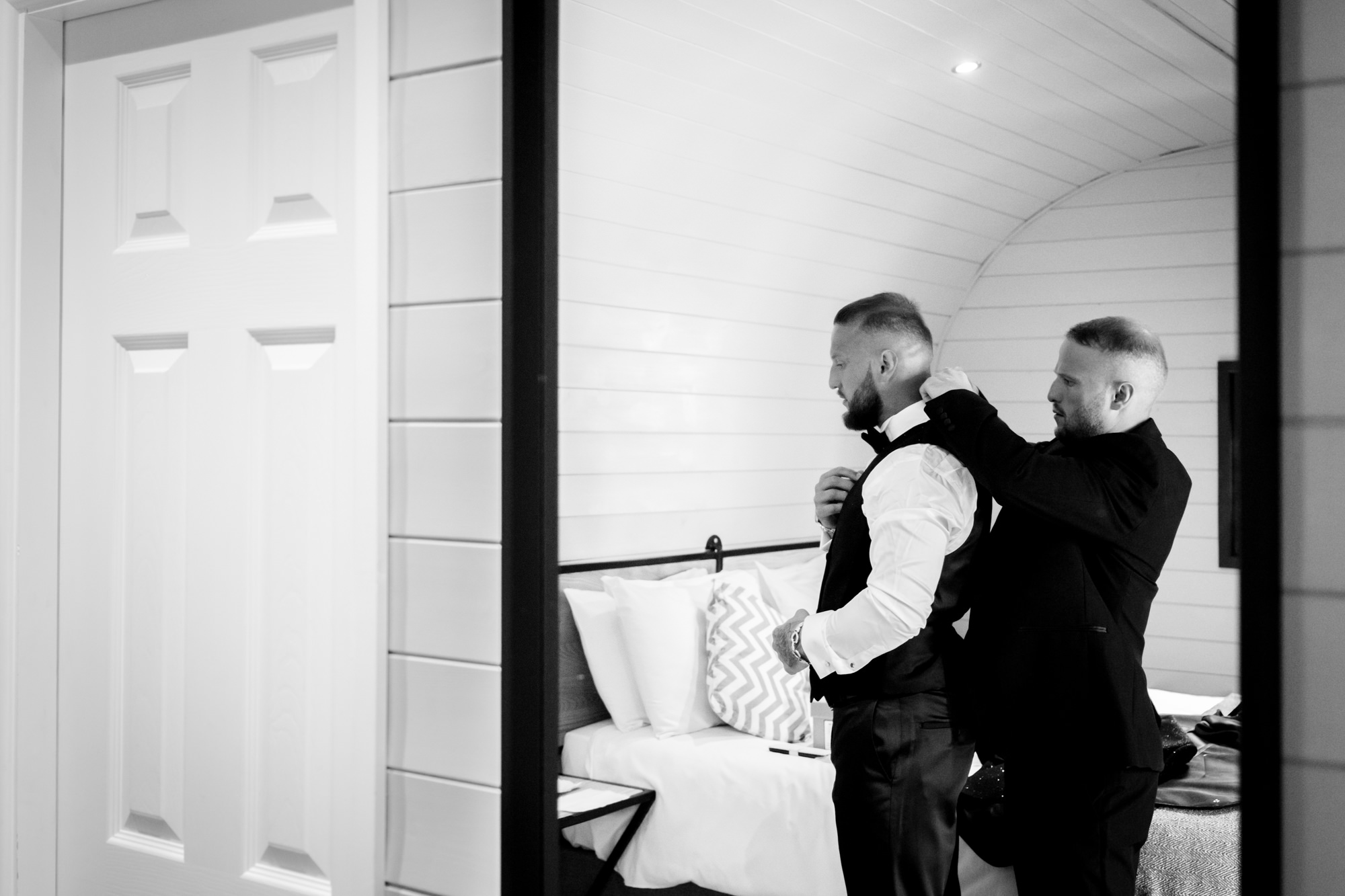 Groom getting dressed in one of the pods at Hanbury Barns