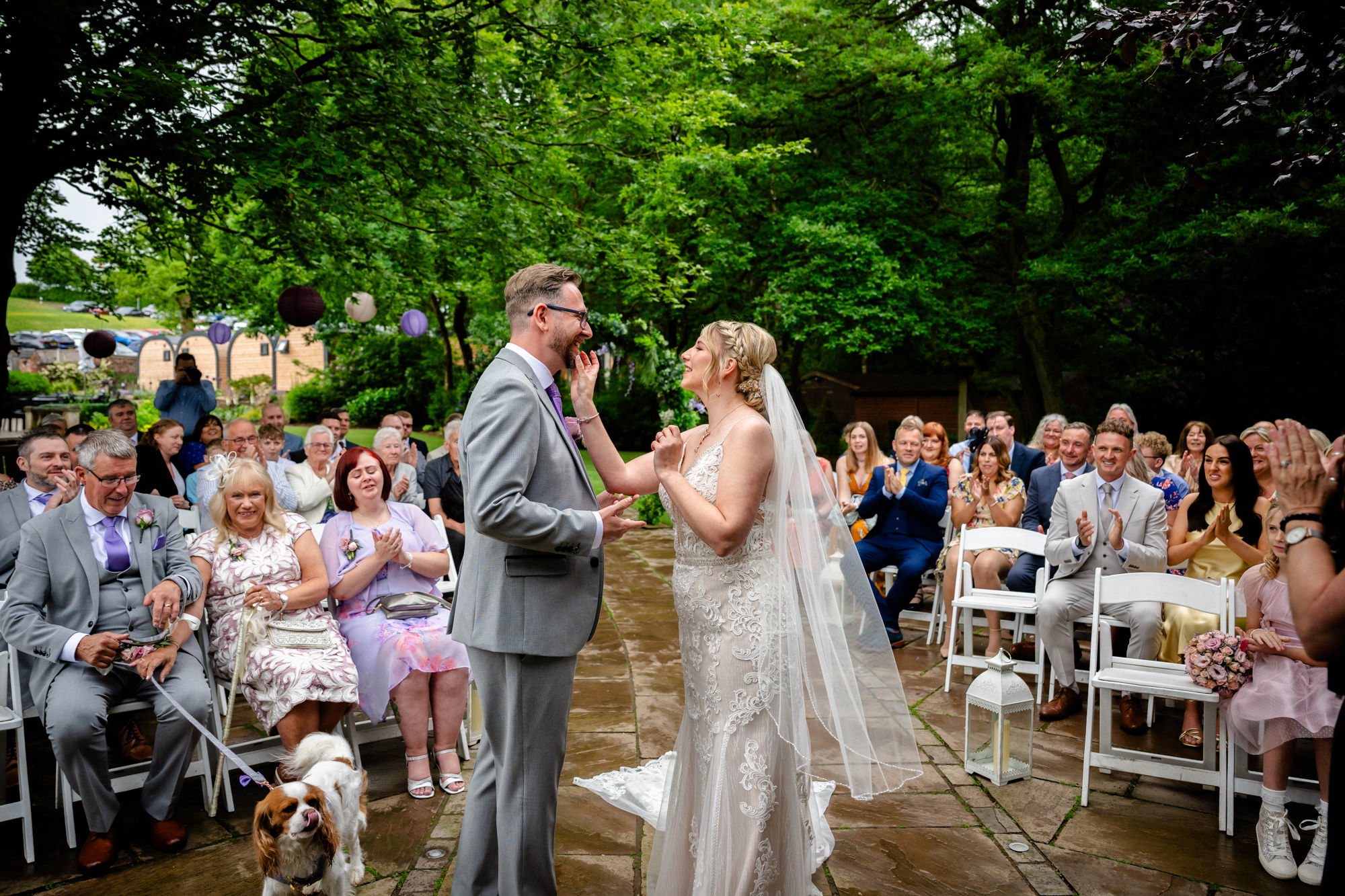 The bride removing her lipstick from the groom's lips after the first kiss at Moddershall Oaks