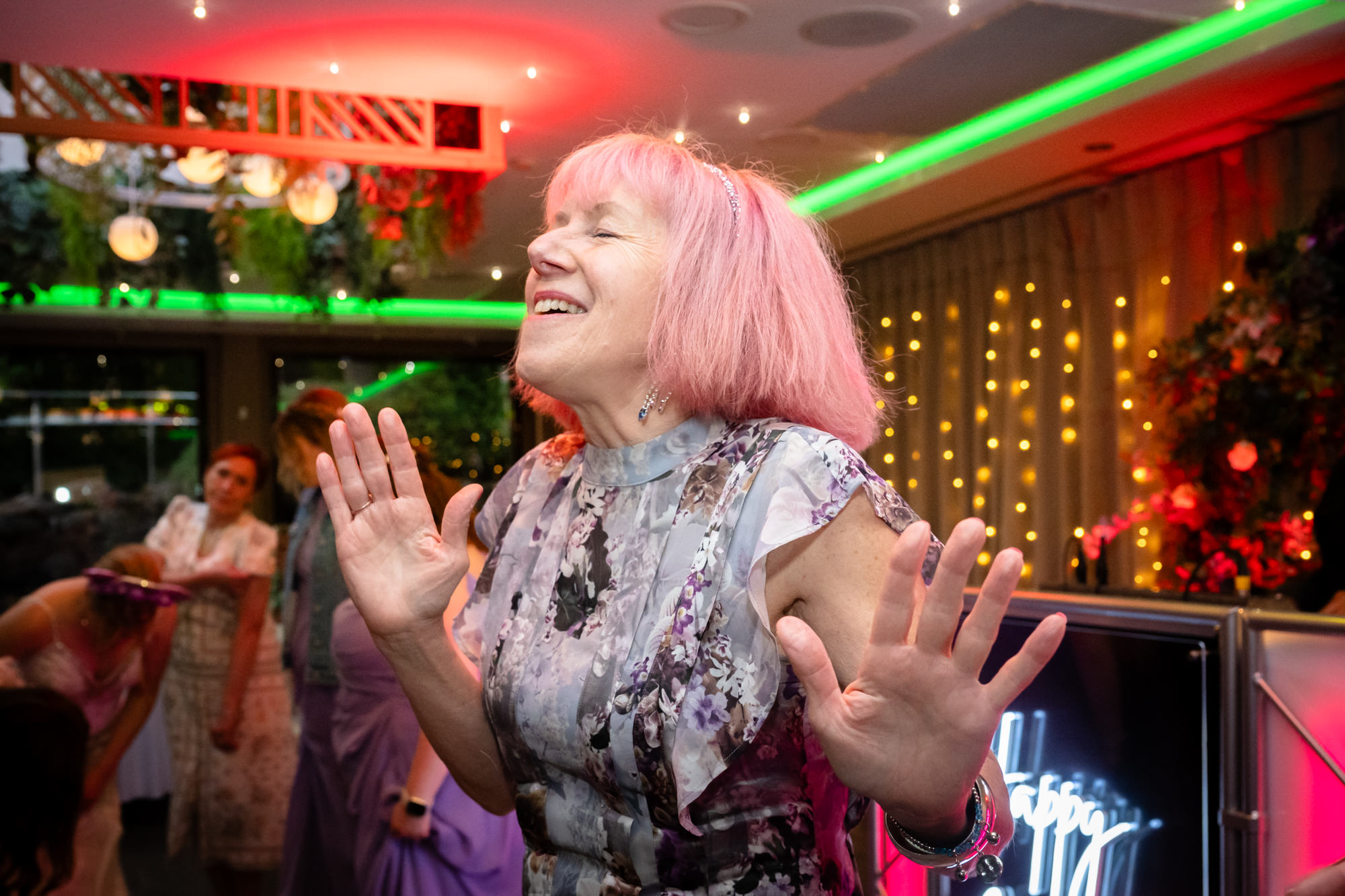A woman with pink hair dancing at Moddershall Oaks.