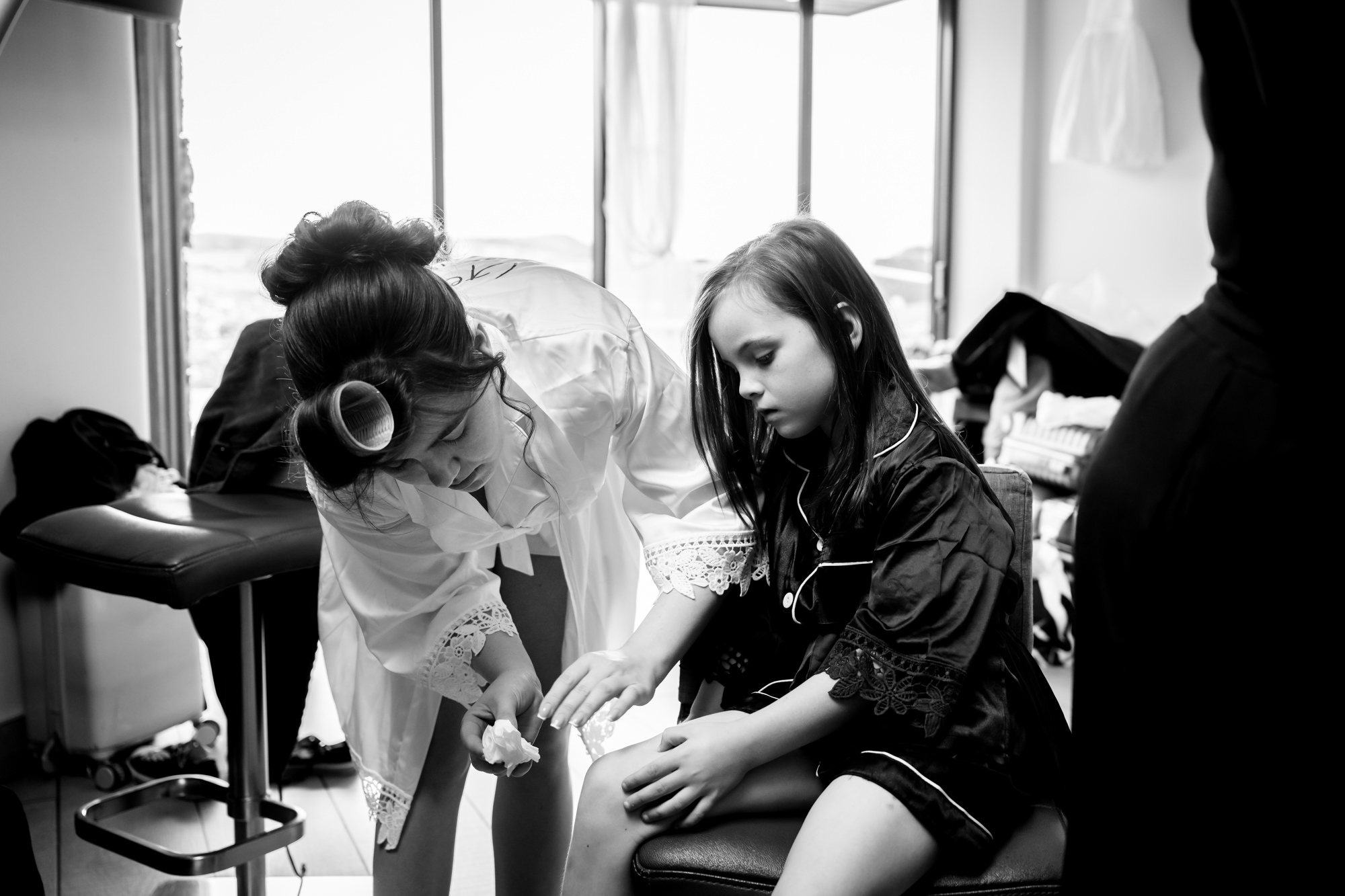 A black and white photo in the Pamper room at Heaton House Farm shows a woman in a satin robe applying something to a young girl's leg.