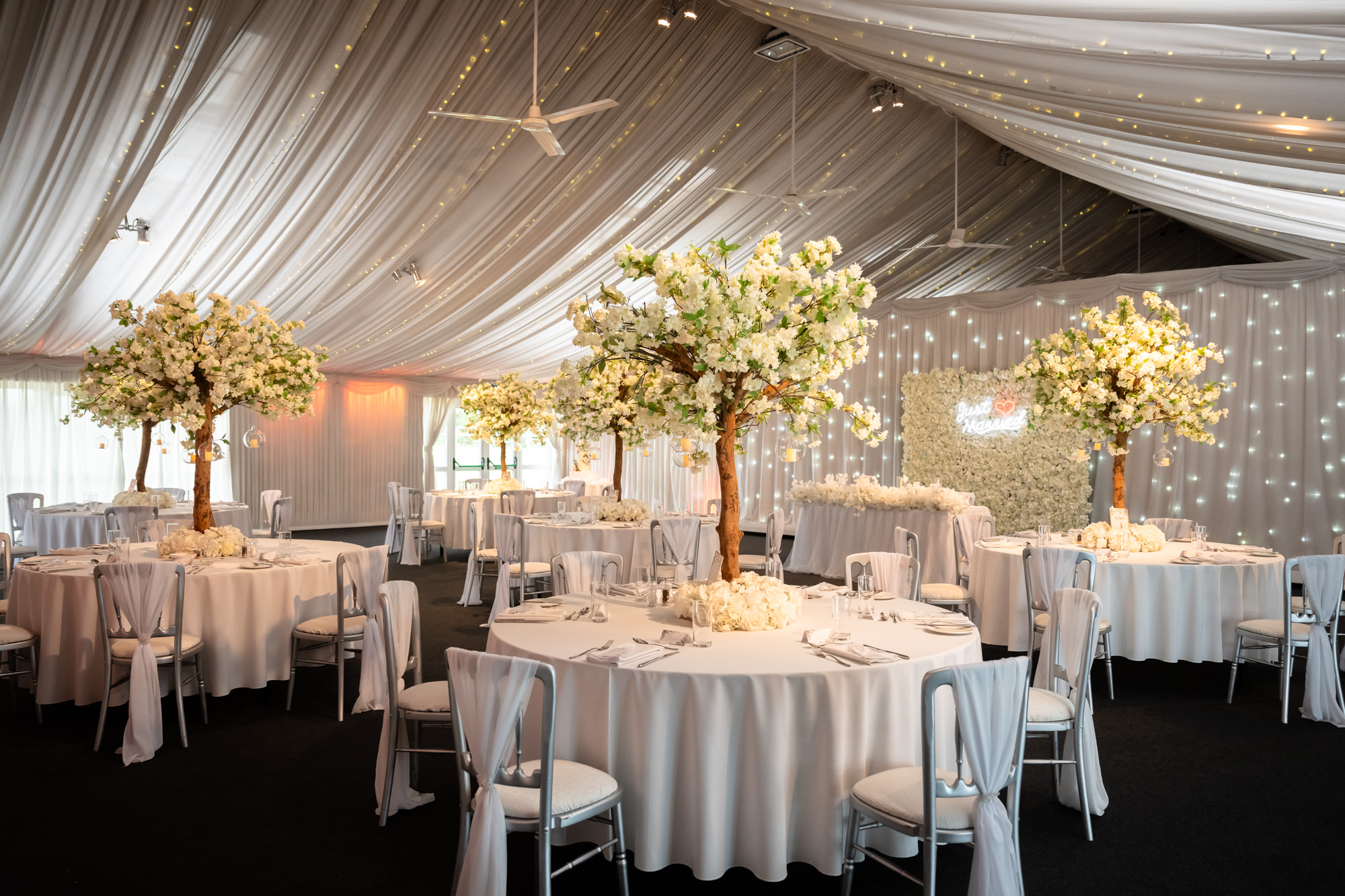 The wedding reception room at Heaton House Farm is beautifully decorated with floral centerpieces on the tables.