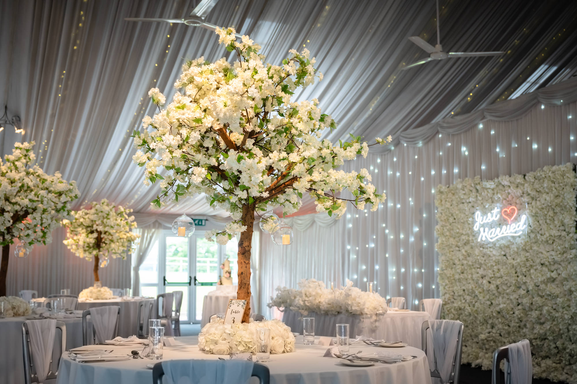 A close-up view of a floral centerpiece on a table in the wedding reception room at Heaton House Farm.