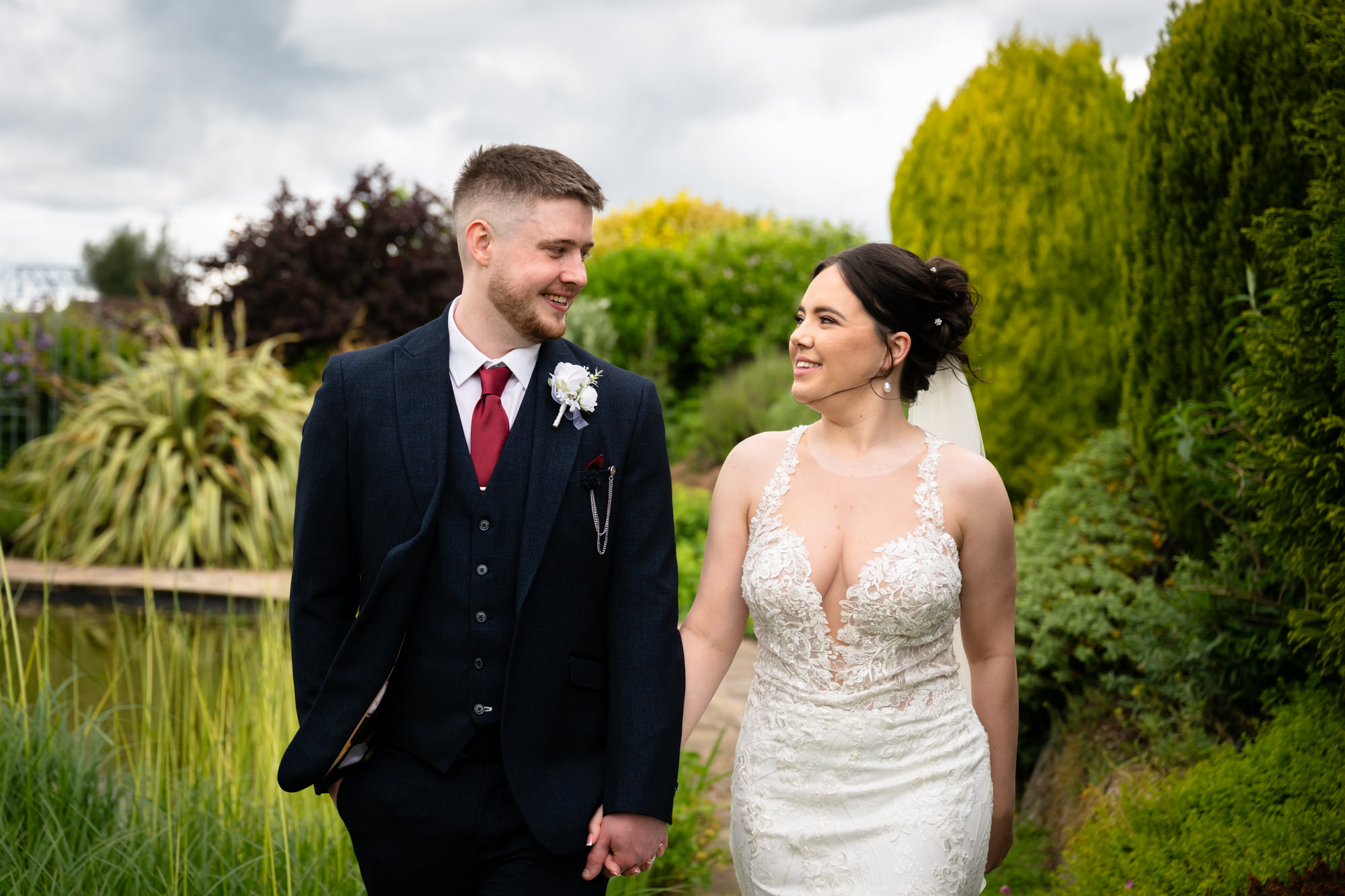 A beautiful moment of the bride and groom looking at each other, walking together for a portrait photo at Heaton House Farm.