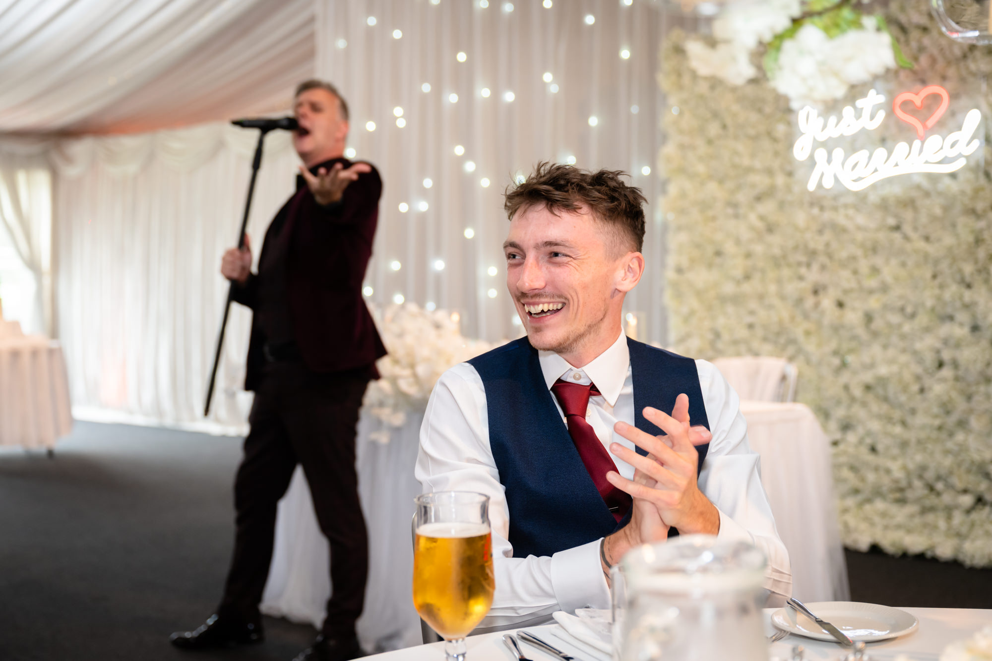 A candid shot of a smiling guest enjoying the wedding breakfast entertainment at Heaton House Farm.