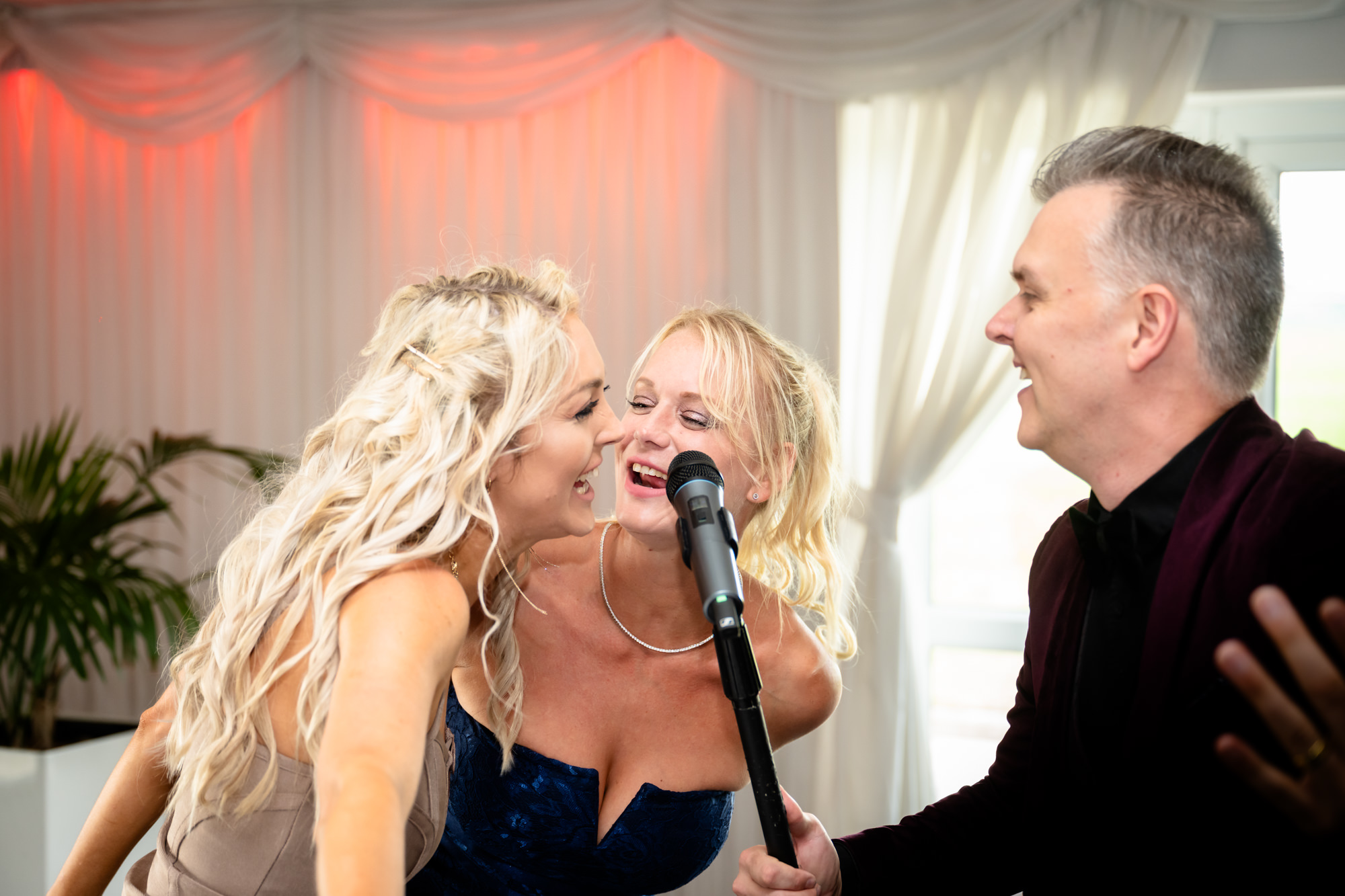 The wedding breakfast entertainment at Heaton House Farm includes a singer interacting with a smiling guest.