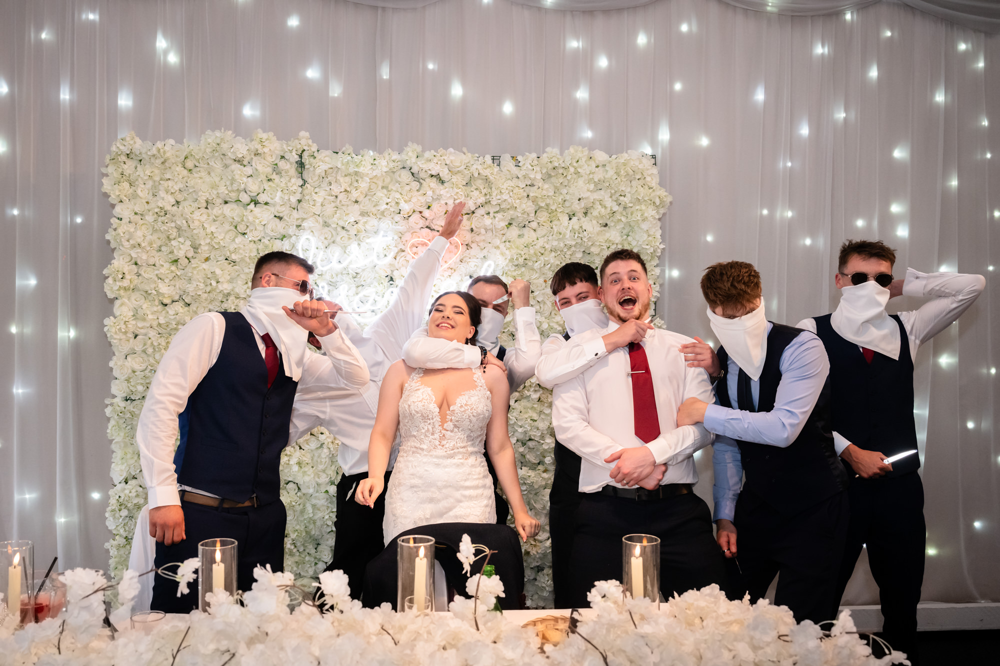 The bride and groom are joined by a group of guests in a lively dash photo at Heaton House Farm.