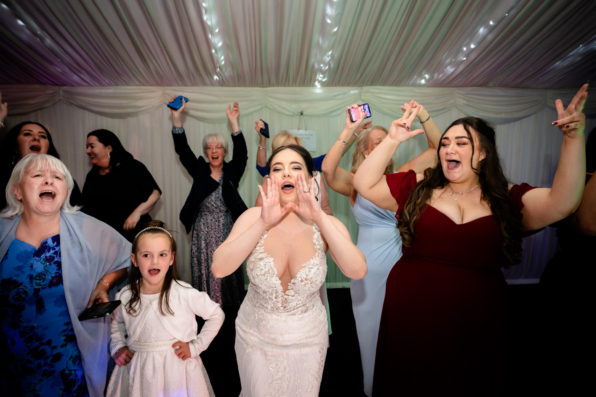 A group of women celebrate and dance at the Heaton House Farm wedding party.