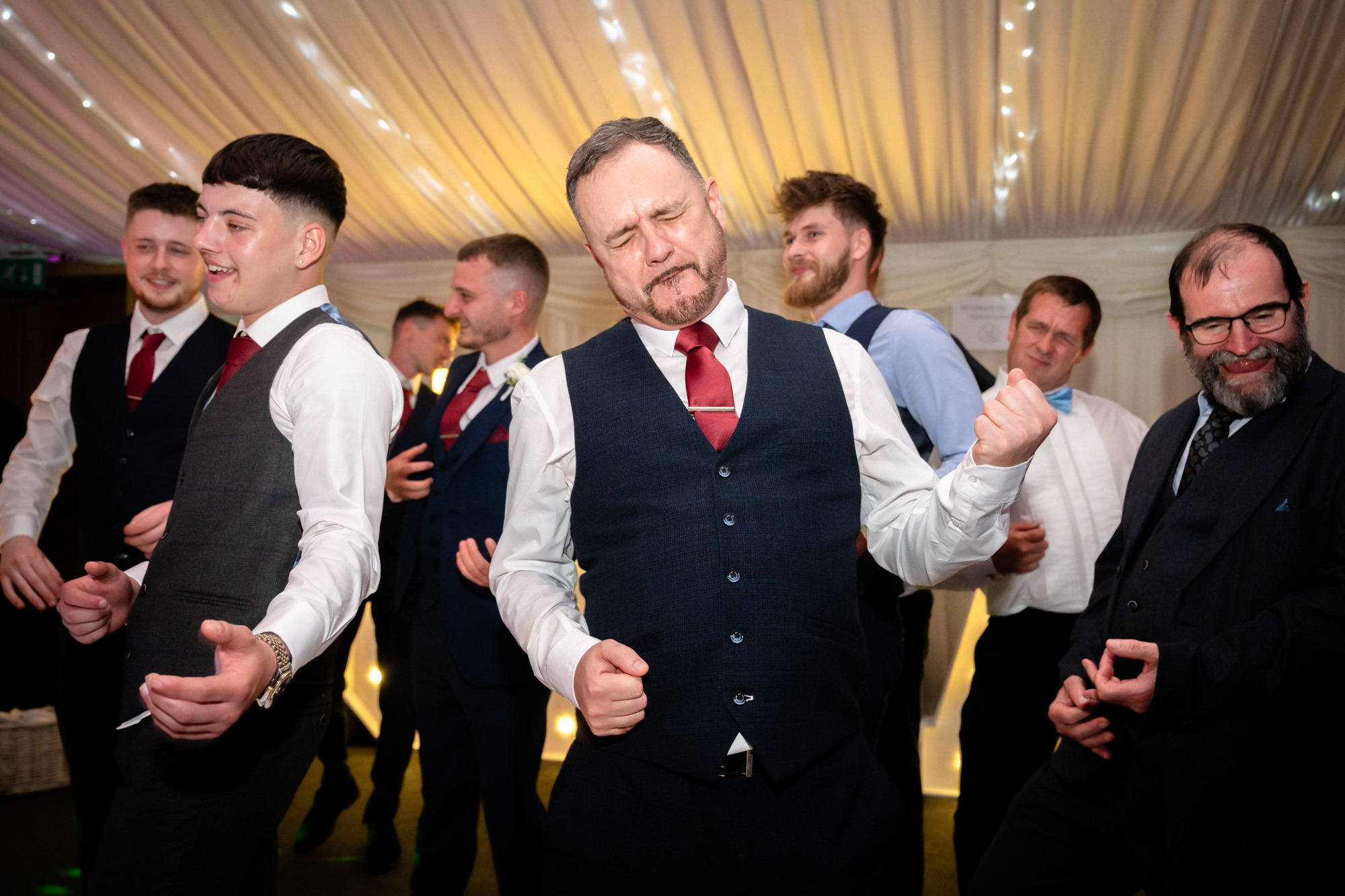 Father of the bride air guitar at the Heaton House Farm wedding party.