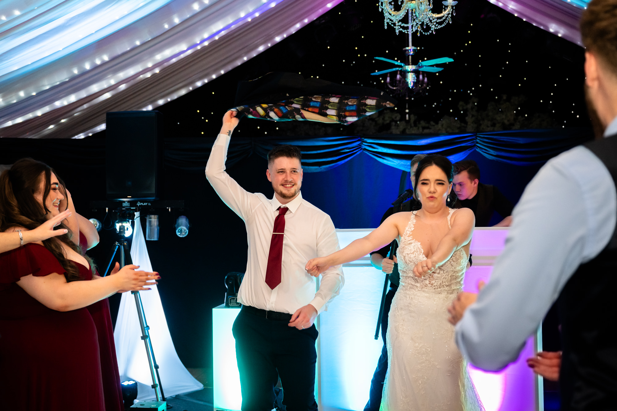 The bride and groom are dancing with the guests at their wedding party at Heaton House Farm.