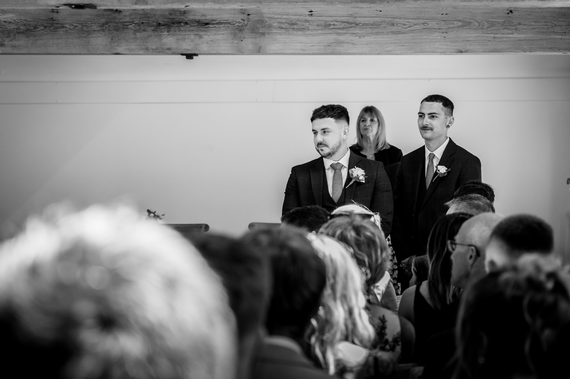 A black and white photo of the groom and best man waiting before the wedding ceremony at Hanbury Barns.
