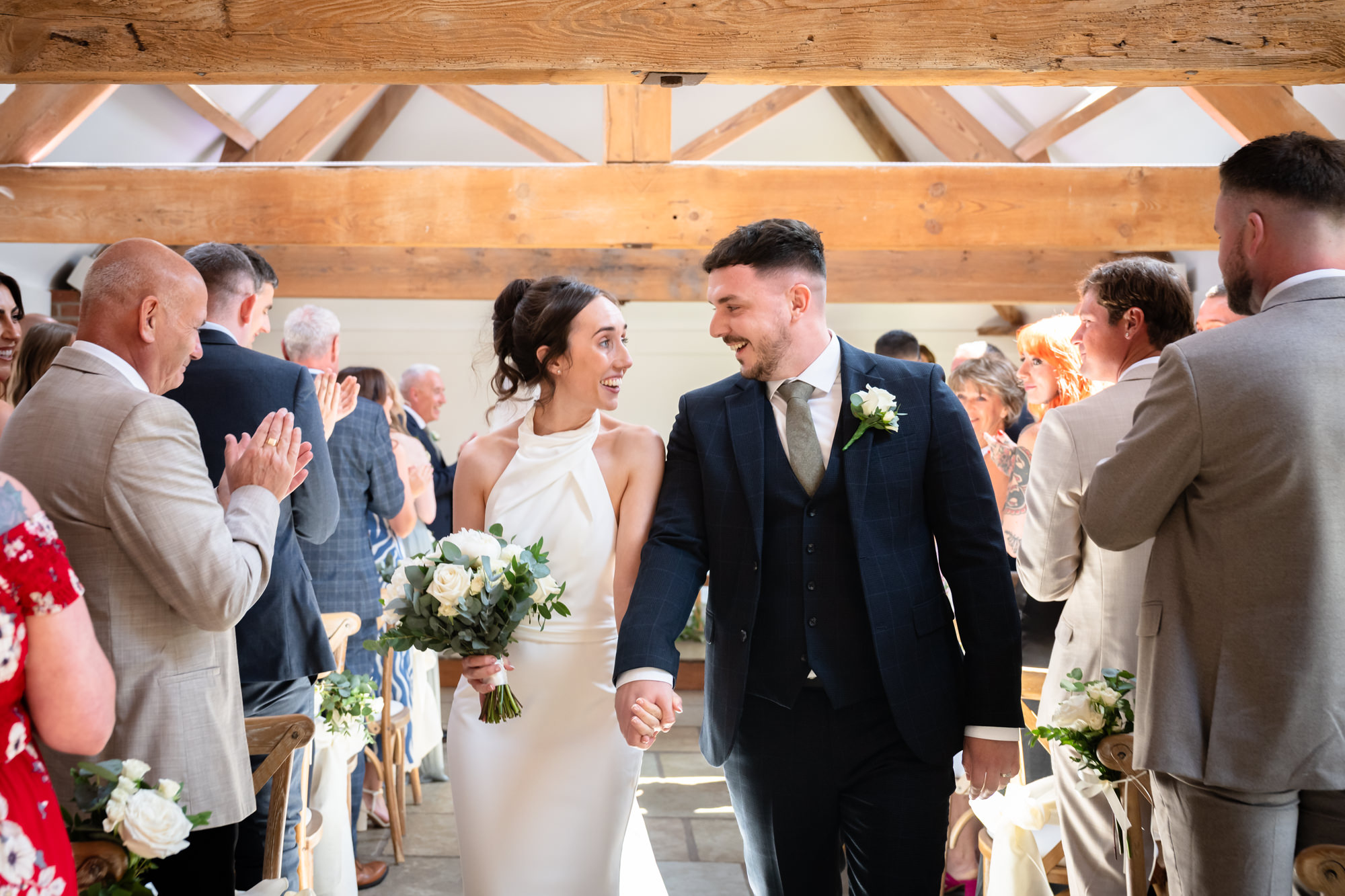 The bride and groom walk down the aisle together after their wedding ceremony at Hanbury Barns.