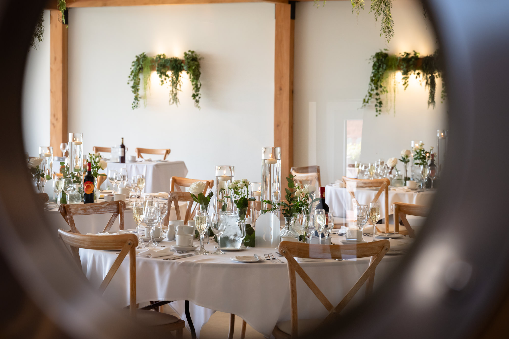 The wedding reception room at Hanbury Barns is decorated with white flowers and candles on the tables.