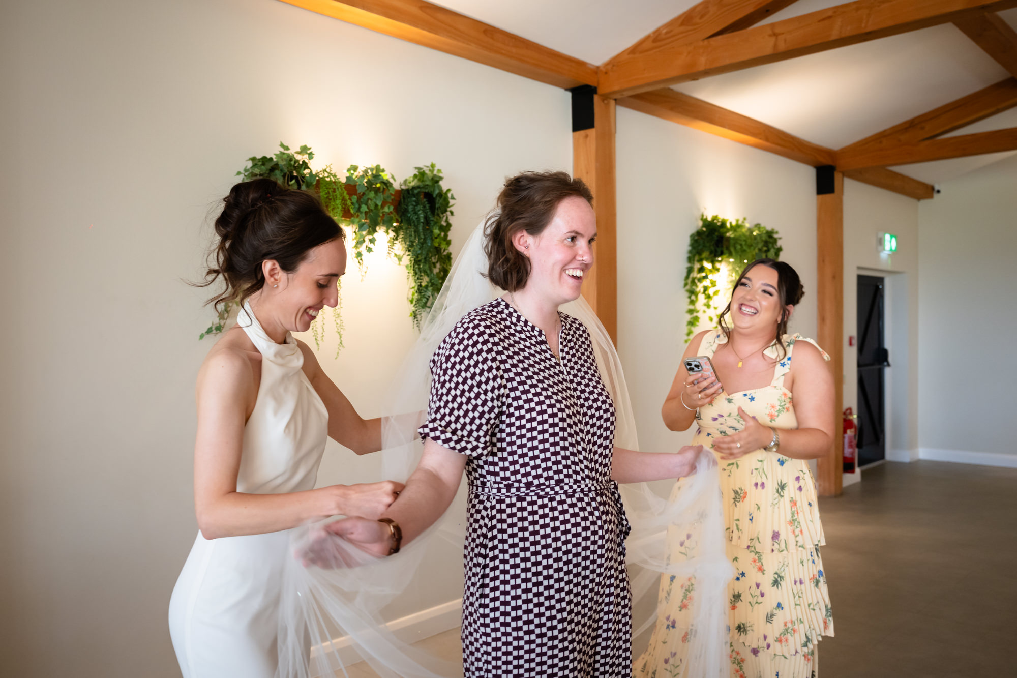 A guest is trying on the bride's veil